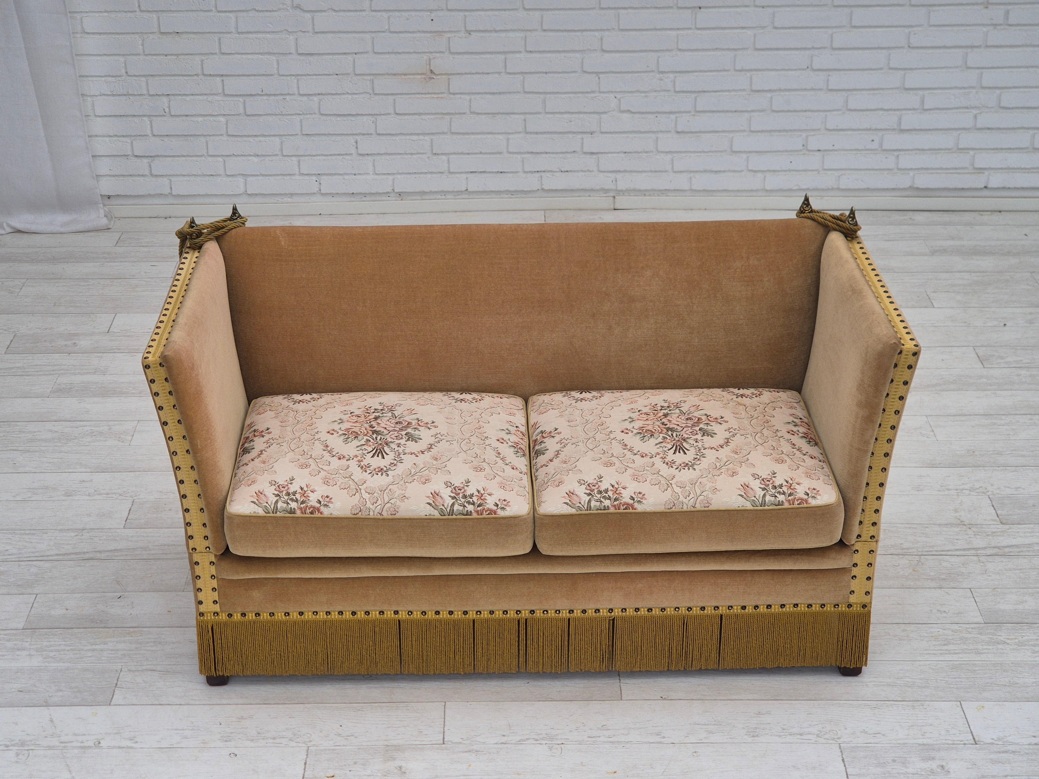 1970s, Danish 2-seater drop arm sofa. Green furniture velour, double sided seat cushions, springs in the seat cushions, ash wood legs, brass strings hooks. Adjustable armrests. Original very good condition: no stains, no smells and stable