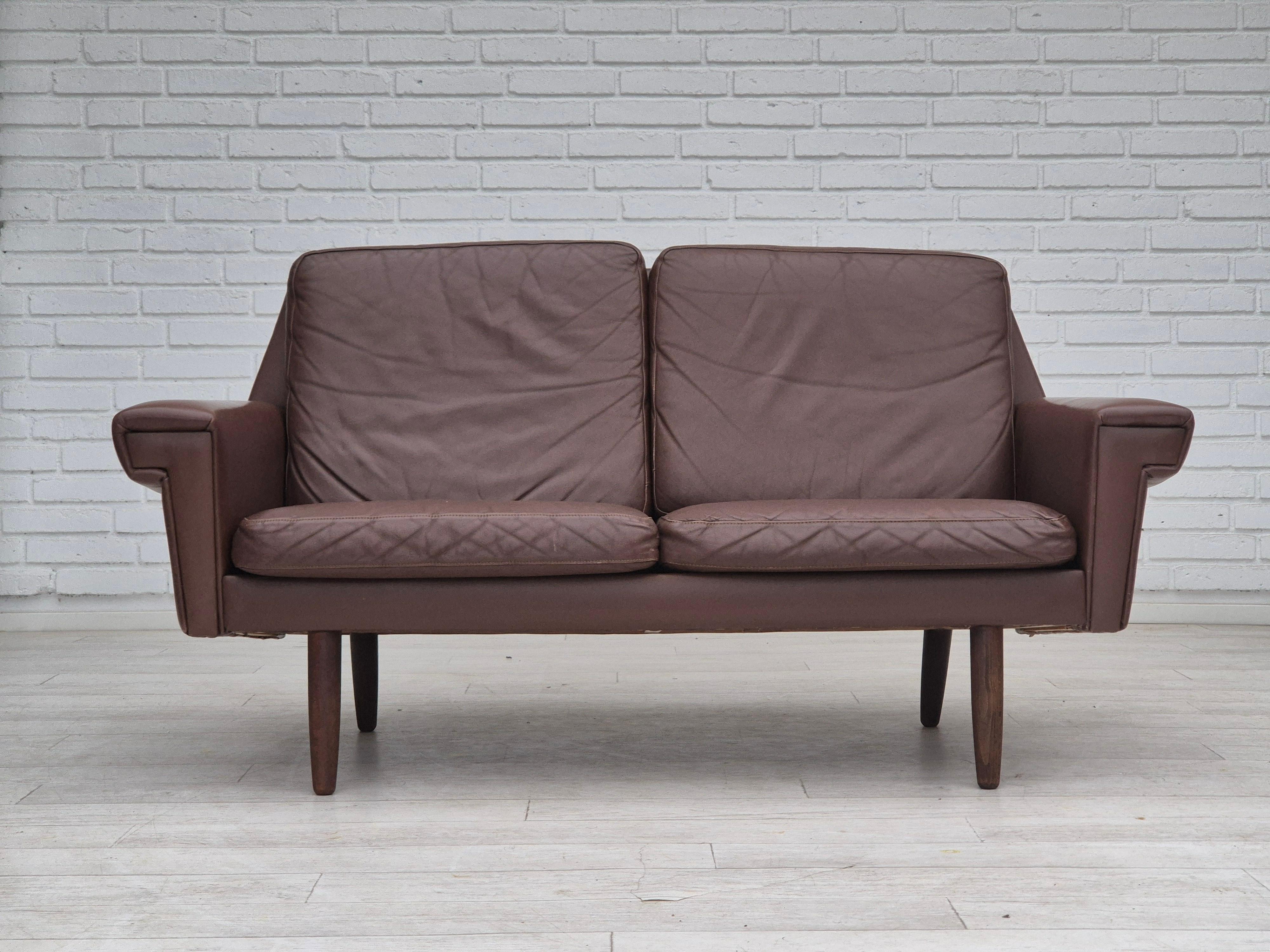 Sofá danés de 2 plazas de los años 70 en muy buen estado original: sin olores ni manchas. Diseño clásico danés de los años 70, una combinación de modernidad con estilo vintage danés. Cuero marrón original, patas de madera de haya. Fabricado por un