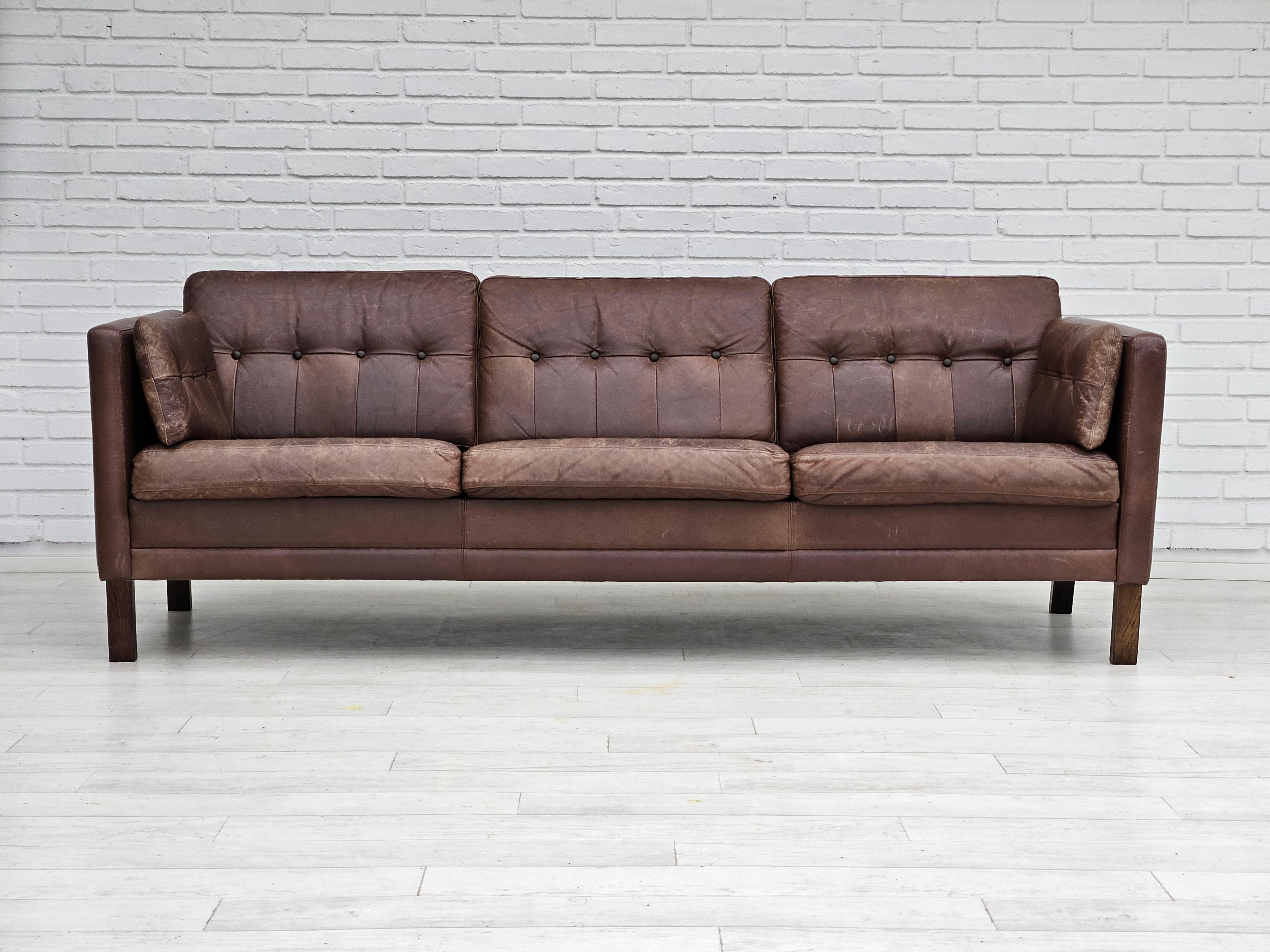 1970s, Danish 3 seater sofa in original good condition: no smells and no stains. Brown leather with nice patina. Beech wood legs. Manufactured by Danish furniture manufacturer in about 1975s. 