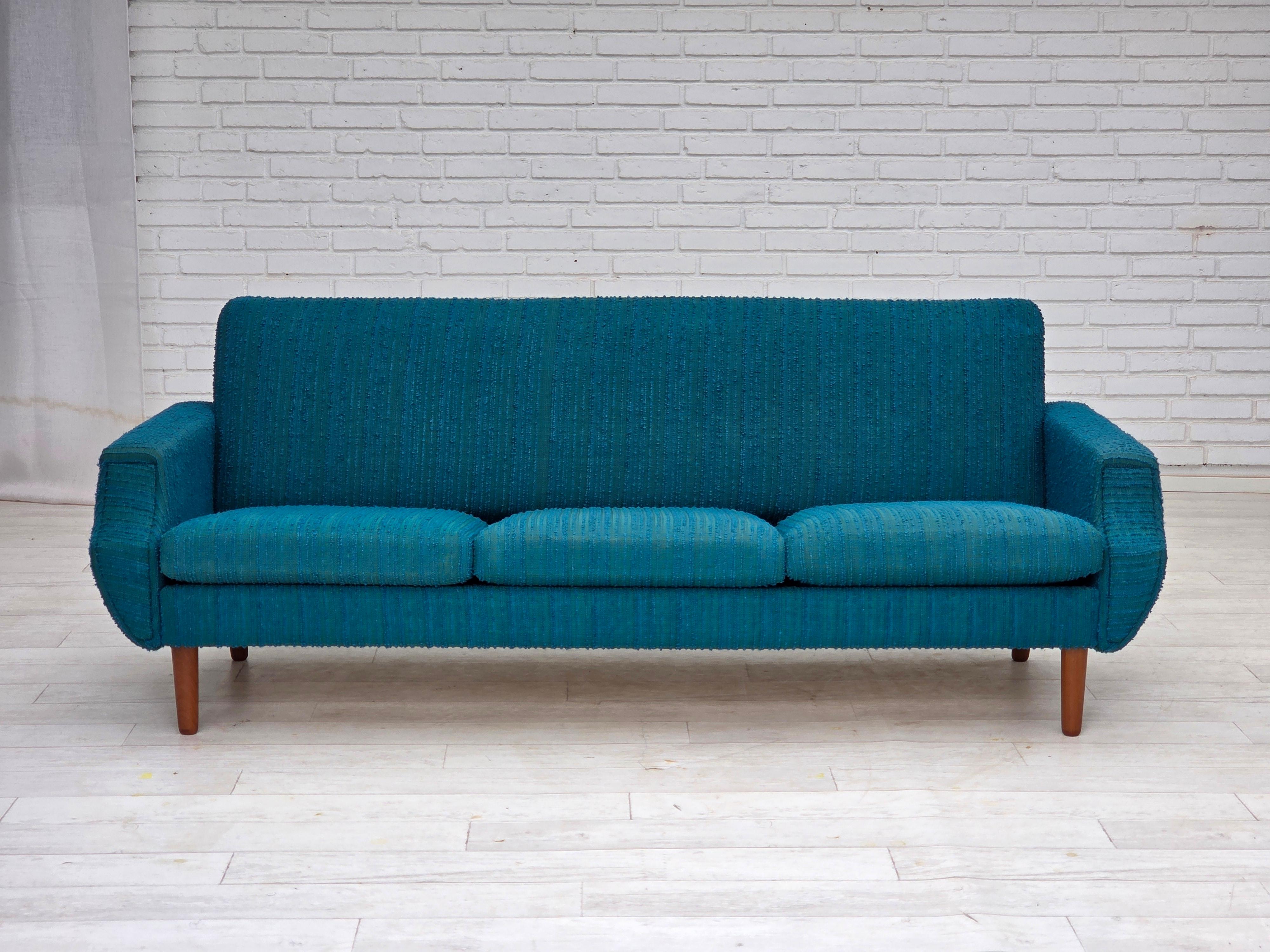 1970s, Danish 3-seater sofa. Original blue/green furniture wool, teak wood legs, springs in the seat cushions. Original good condition: no smells, no stains and stable construction. Manufactured by Danish furniture maker in about 1970-75s. Original