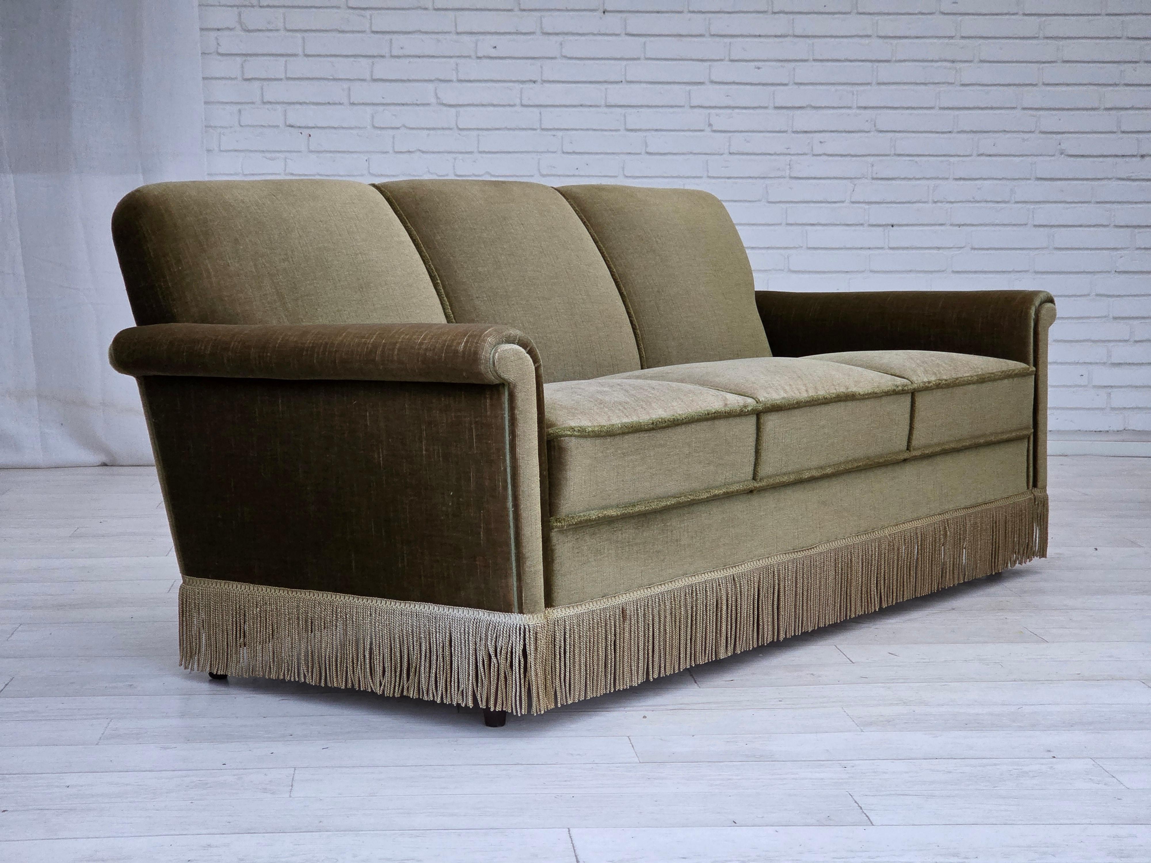 Divano danese a 3 posti degli anni '70. Velluto verde originale, gambe in legno di teak, molle nella seduta. Condizioni originali molto buone: nessun odore, nessuna macchia e struttura stabile. Prodotto da un produttore di mobili danese negli anni