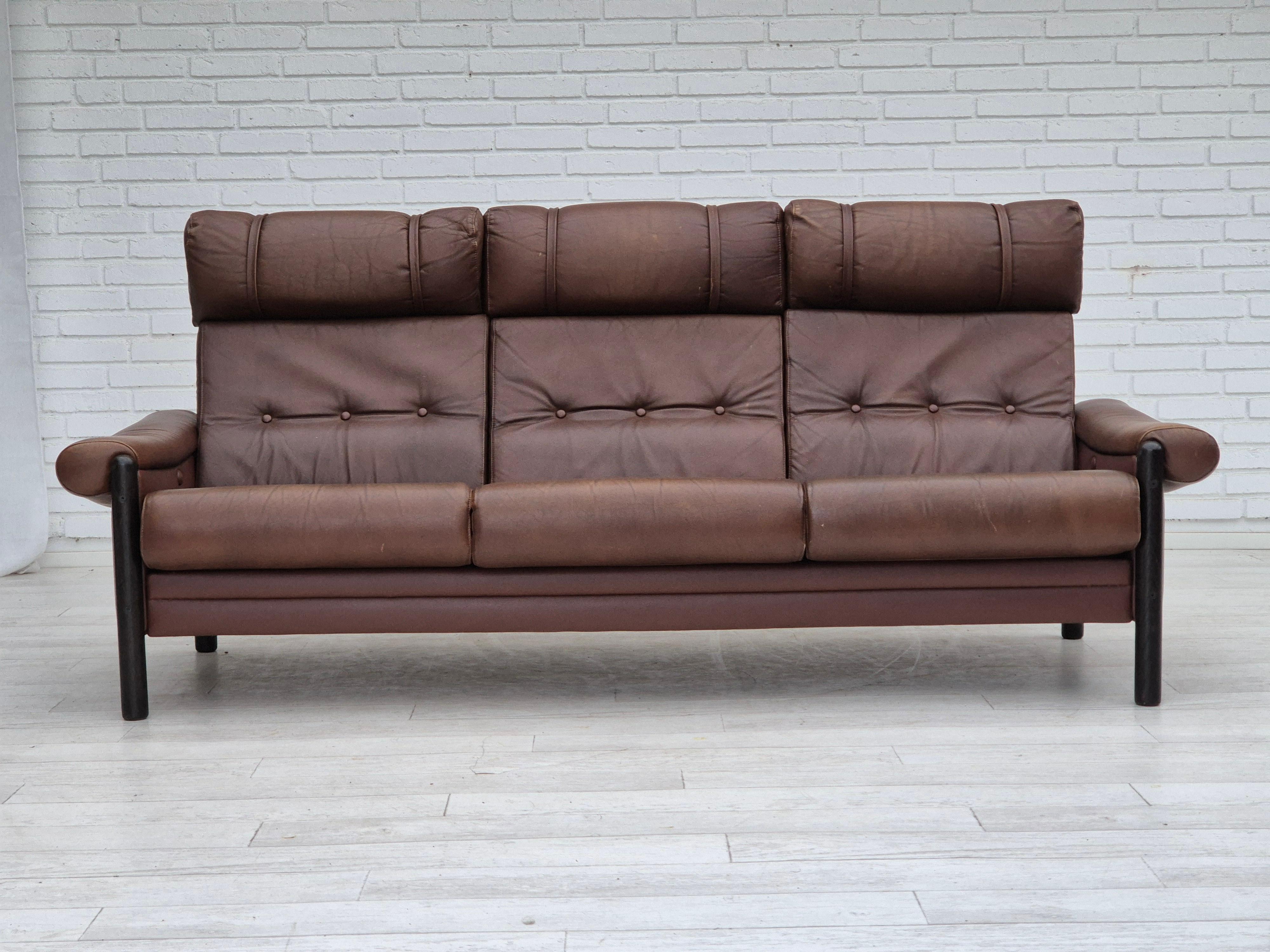 1970s, Danish 3-seater sofa. Original good condition: no smells, no stains, and stable construction. Original brown furniture leather, dark oak wood. The sofa was bought by the previous owner in 1978s. Manufactured by Danish furniture maker in
