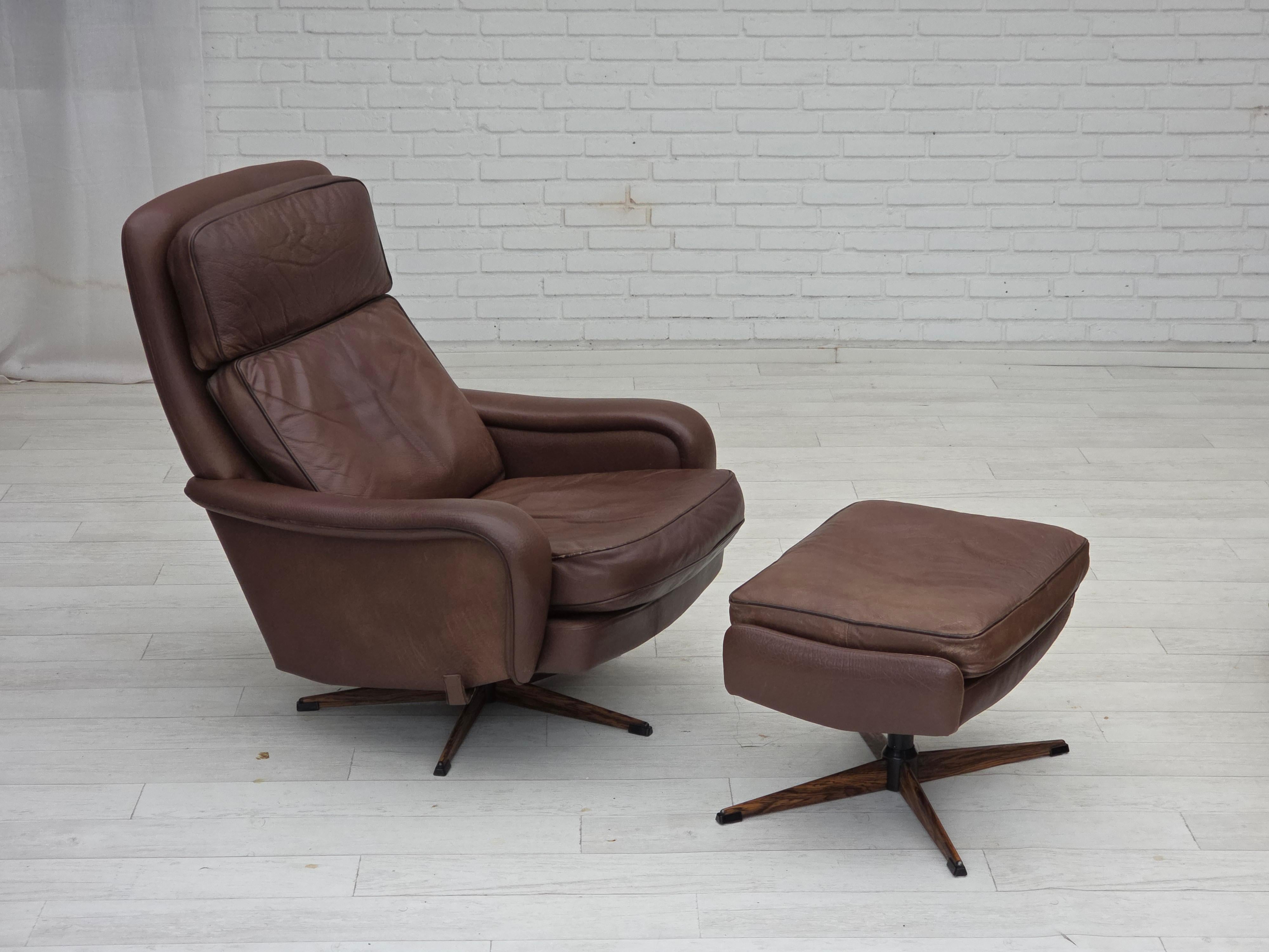 Poltrona girevole regolabile danese degli anni '70 con poggiapiedi di Madsen & Schubell. Pelle originale del mobile marrone, base in acciaio a imitazione del legno. Condizioni originali molto buone: nessun odore, nessuna macchia. Prodotto da un