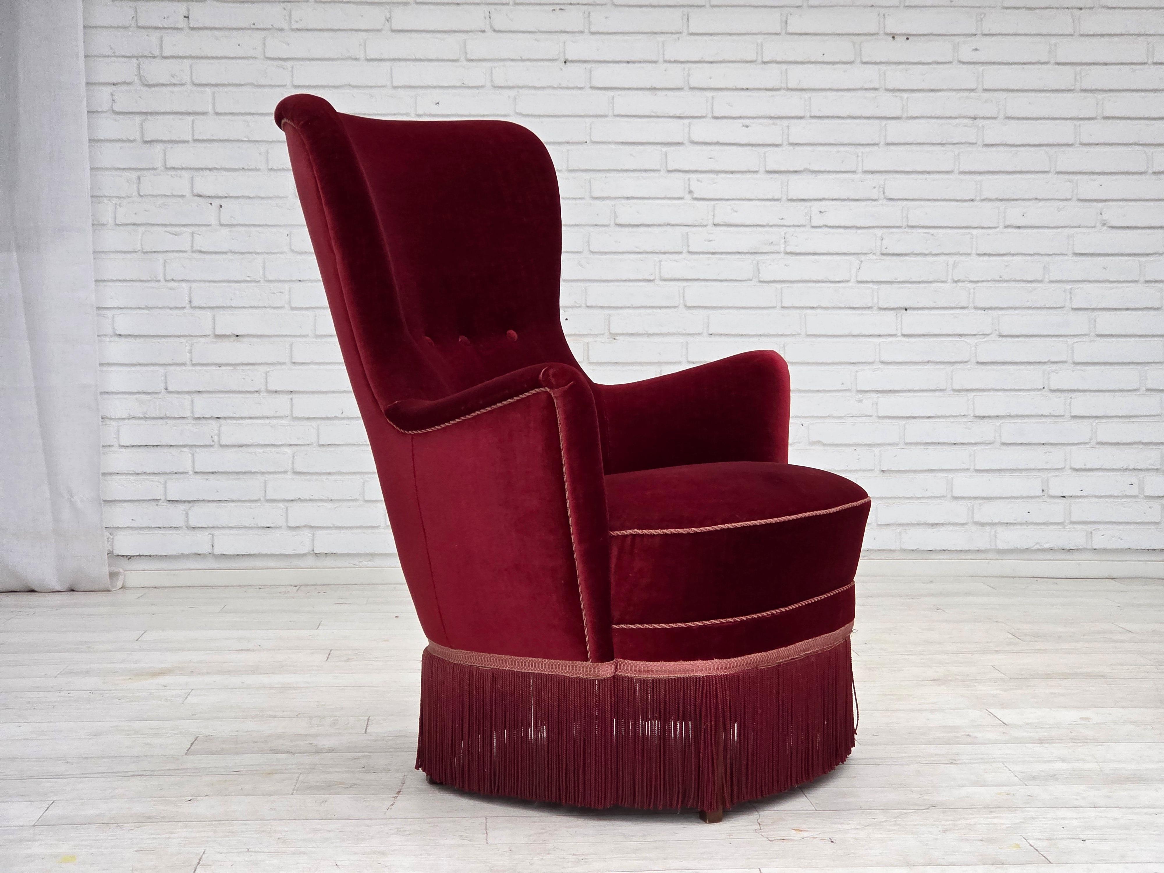 Años 70, sillón danés. Muebles de terciopelo rojo cereza, patas de madera de fresno, muelles en el asiento. Buen estado original: sin olores, sin manchas y construcción estable. Fabricado por un fabricante de muebles danés entre 1970 y 1975.