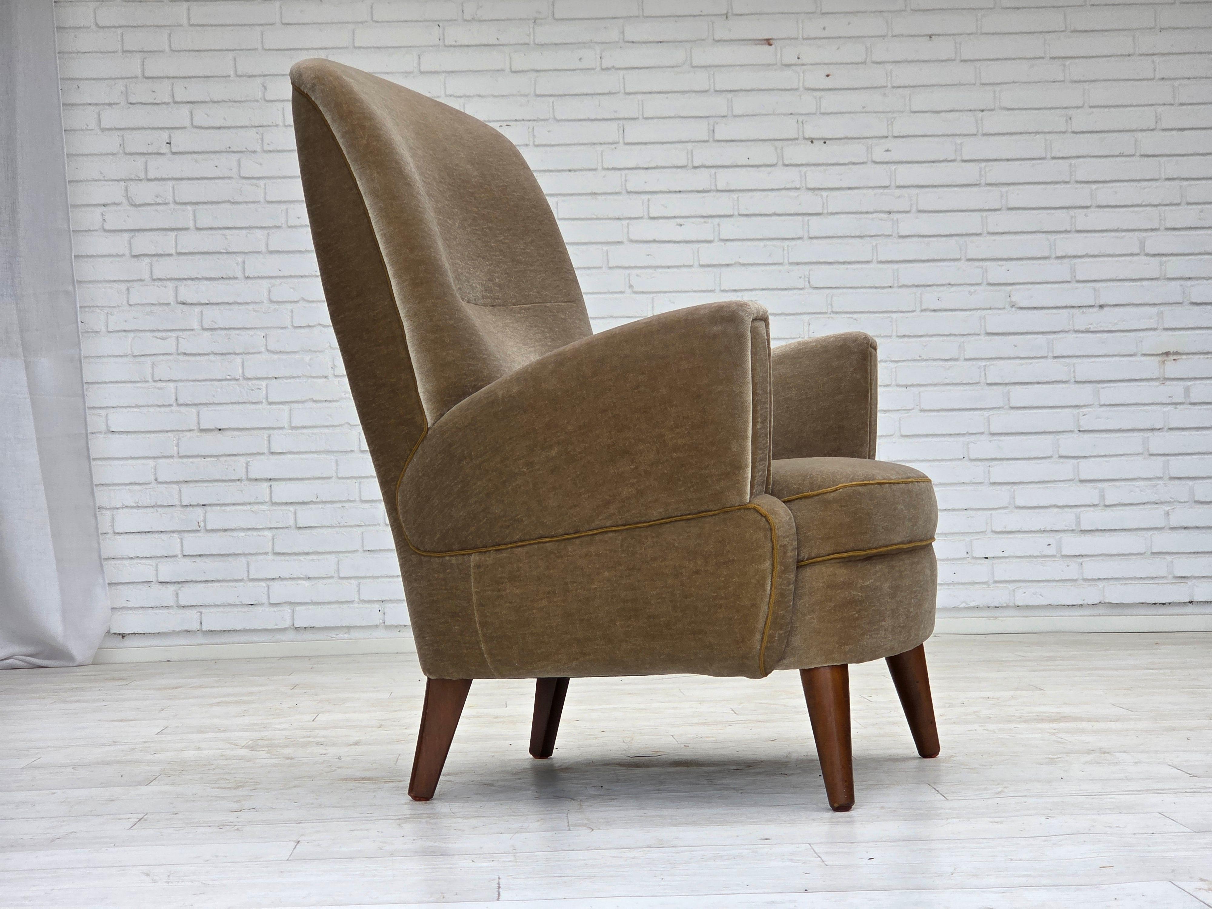 1970, fauteuil danois. Velours d'ameublement vert, pieds en bois de hêtre, ressorts dans l'assise. La chaise a été retapissée il y a environ 15 ans par un artisan. Très bon état : pas d'odeurs, pas de taches et construction stable. Fabriqué par un