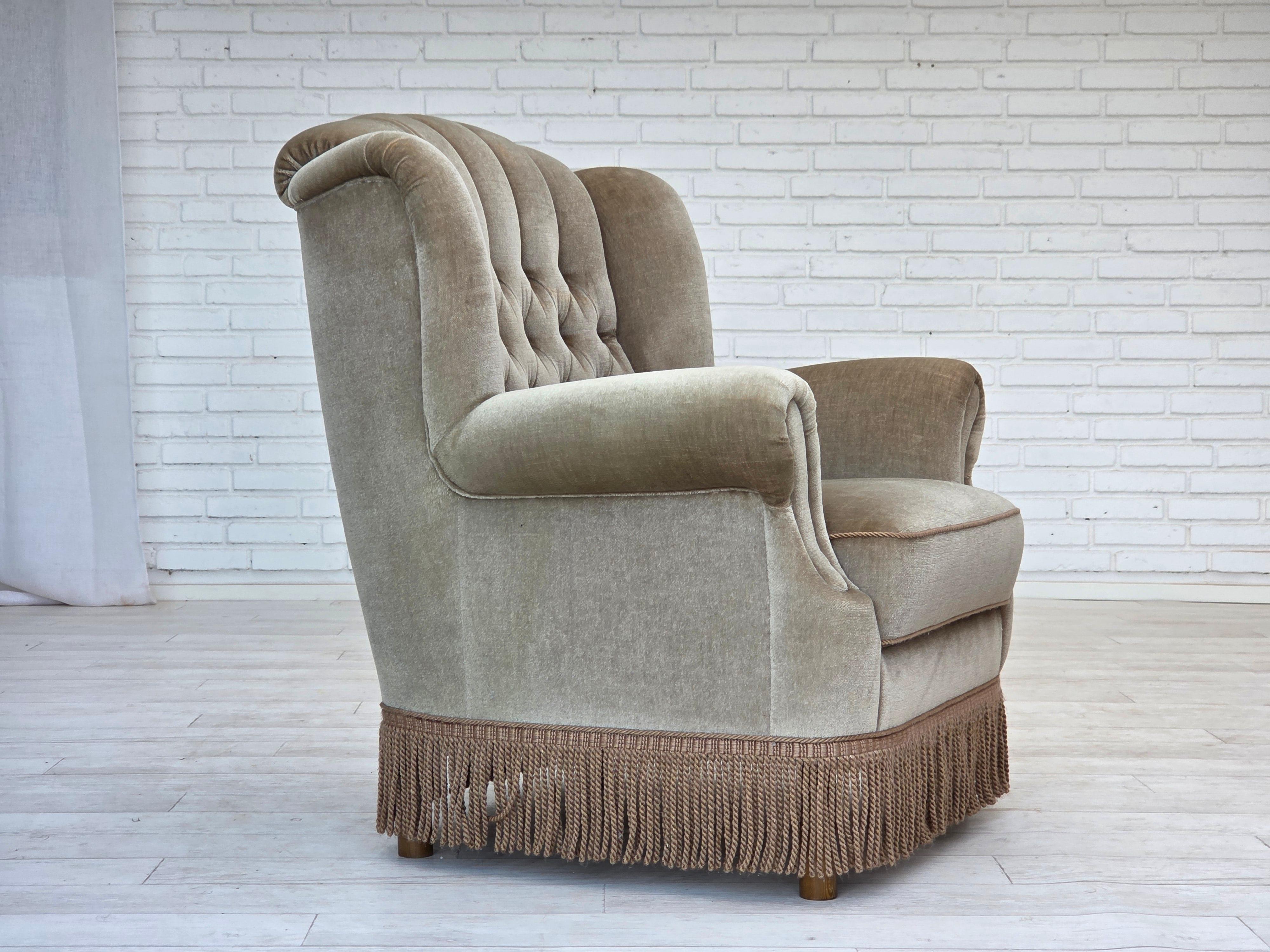 1970, fauteuil danois. Très bon état d'origine : pas d'odeurs, pas de taches et construction stable. Velours d'ameublement vert clair, pieds en bois de Beeche, ressorts dans l'assise. Fabriqué par un fabricant de meubles danois dans les années
