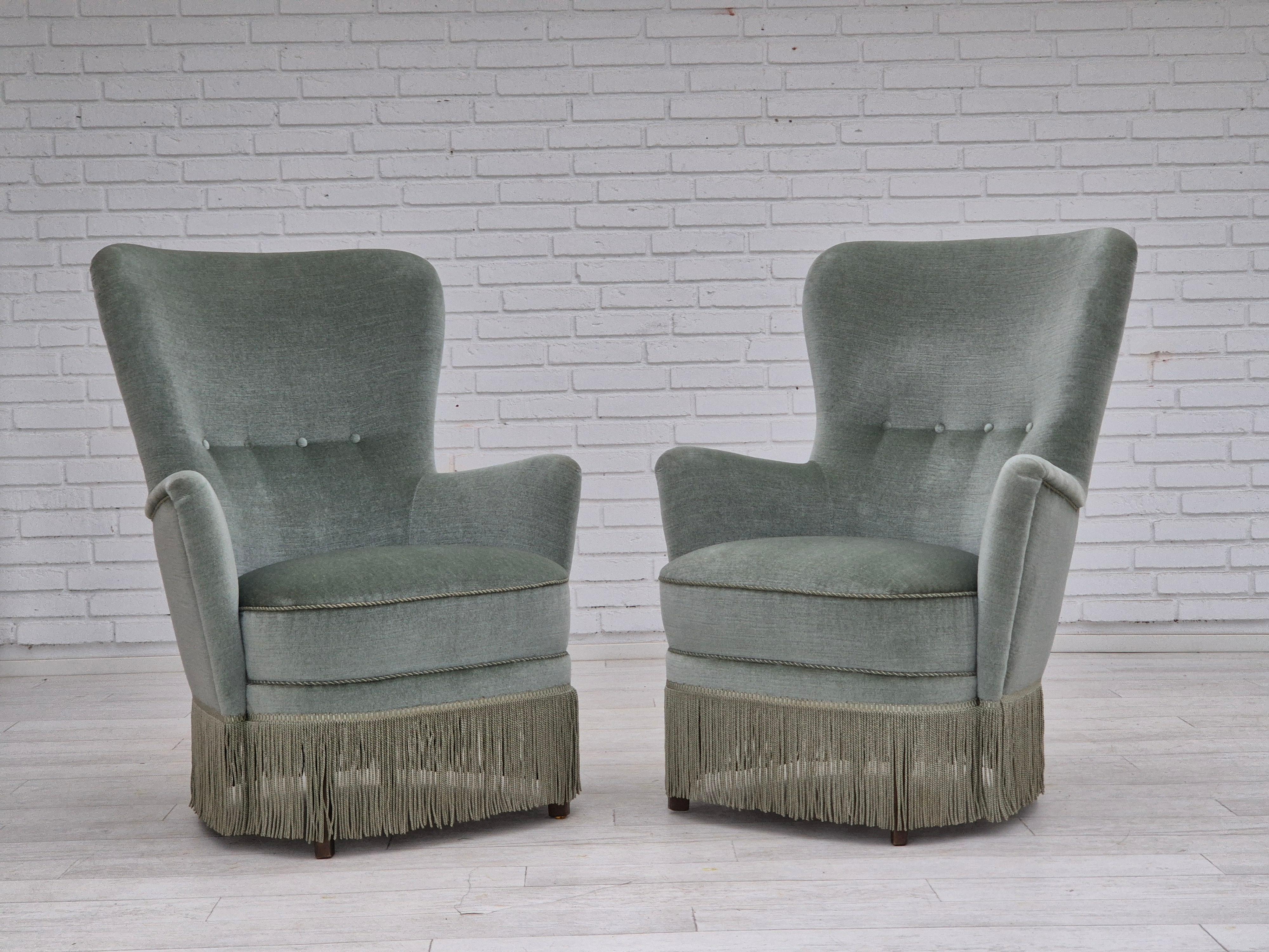 Poltrona danese degli anni '70 in ottime condizioni originali: nessun odore, nessuna macchia e struttura stabile. Velluto originale verde chiaro per mobili, molle in ottone nella seduta, gambe in legno di faggio. Prodotto da un produttore di mobili