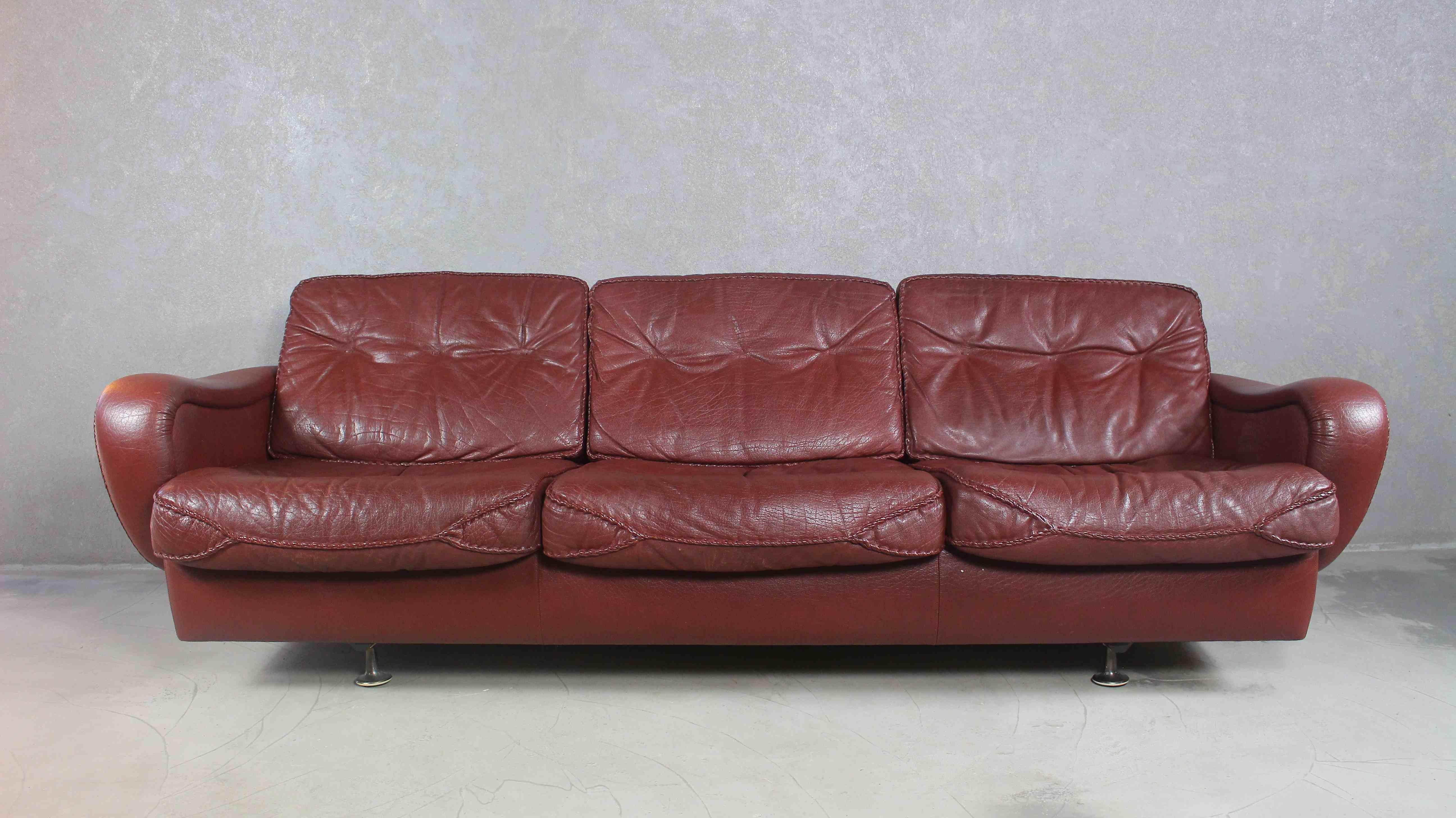 Un canapé danois très élégant des années 1970, conçu par le célèbre duo de designers Acton Schubell et IB Madsen.
Le canapé est entièrement recouvert de cuir de buffle texturé véritable, de couleur marron.
Les coussins du dossier sont ornés de