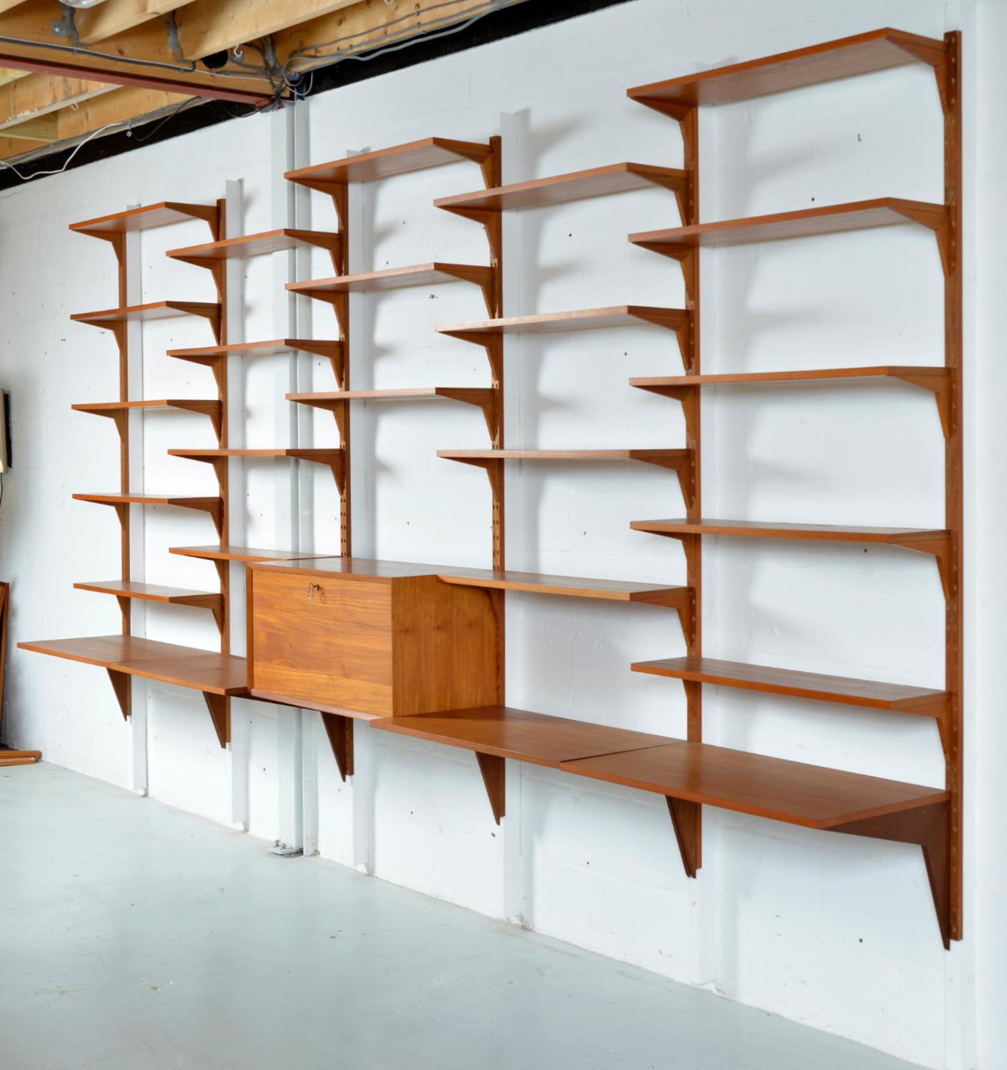 Superbe système d'étagères CADO à cinq travées en teck danois des années 1970, conçu par Paul Cadovius, composé de 32 pièces, y compris les montants, et de 50 supports. Ces étagères design sont entièrement modulables, ce qui permet un vaste choix de