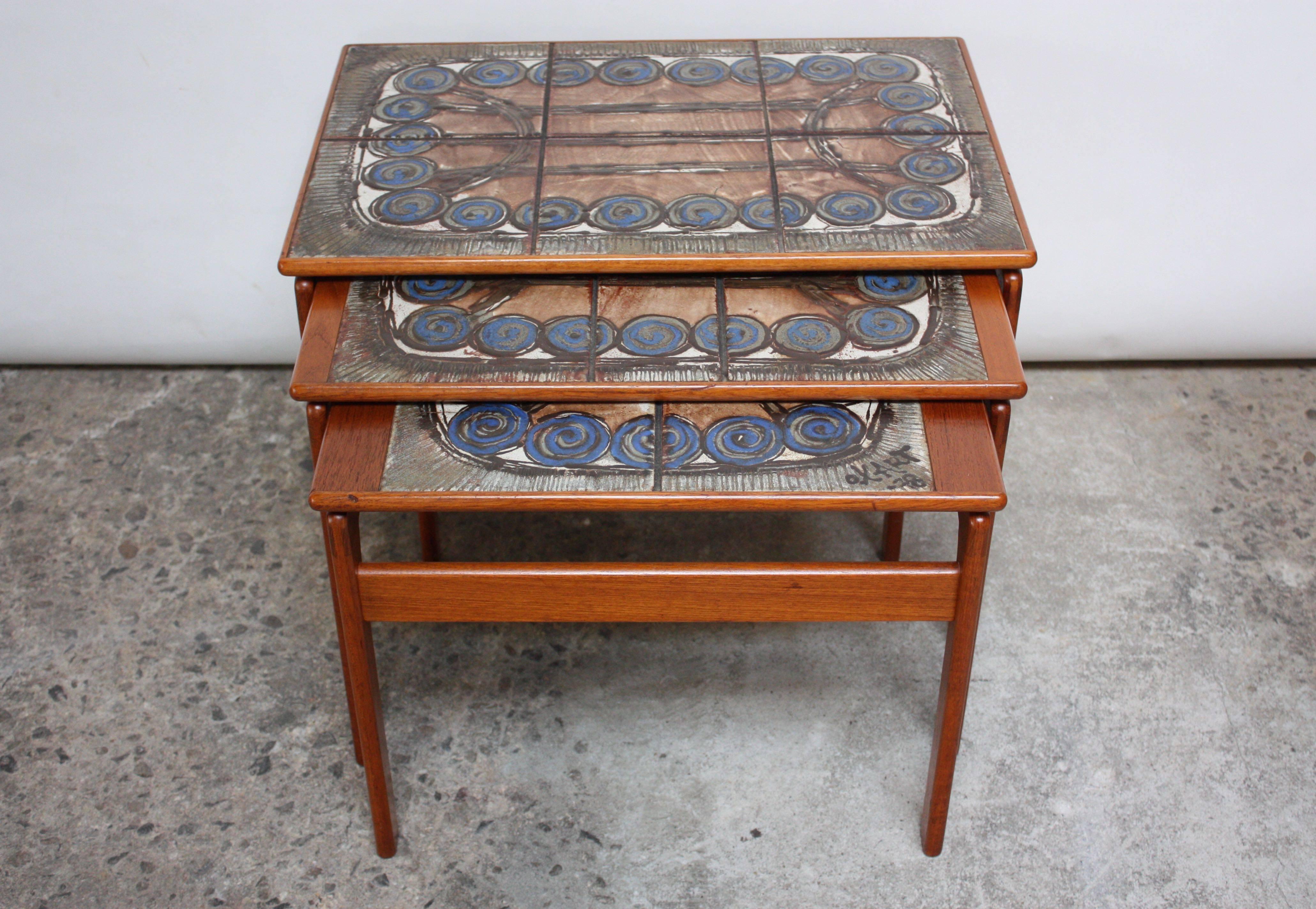 Trio of Ox Art teak nesting tables composed of a ceramic tile arrangement with circular spiral and linear pattern motif. The tables are well constructed, utilizing wood joinery techniques and internal dowels that hold each table in place.
Signed