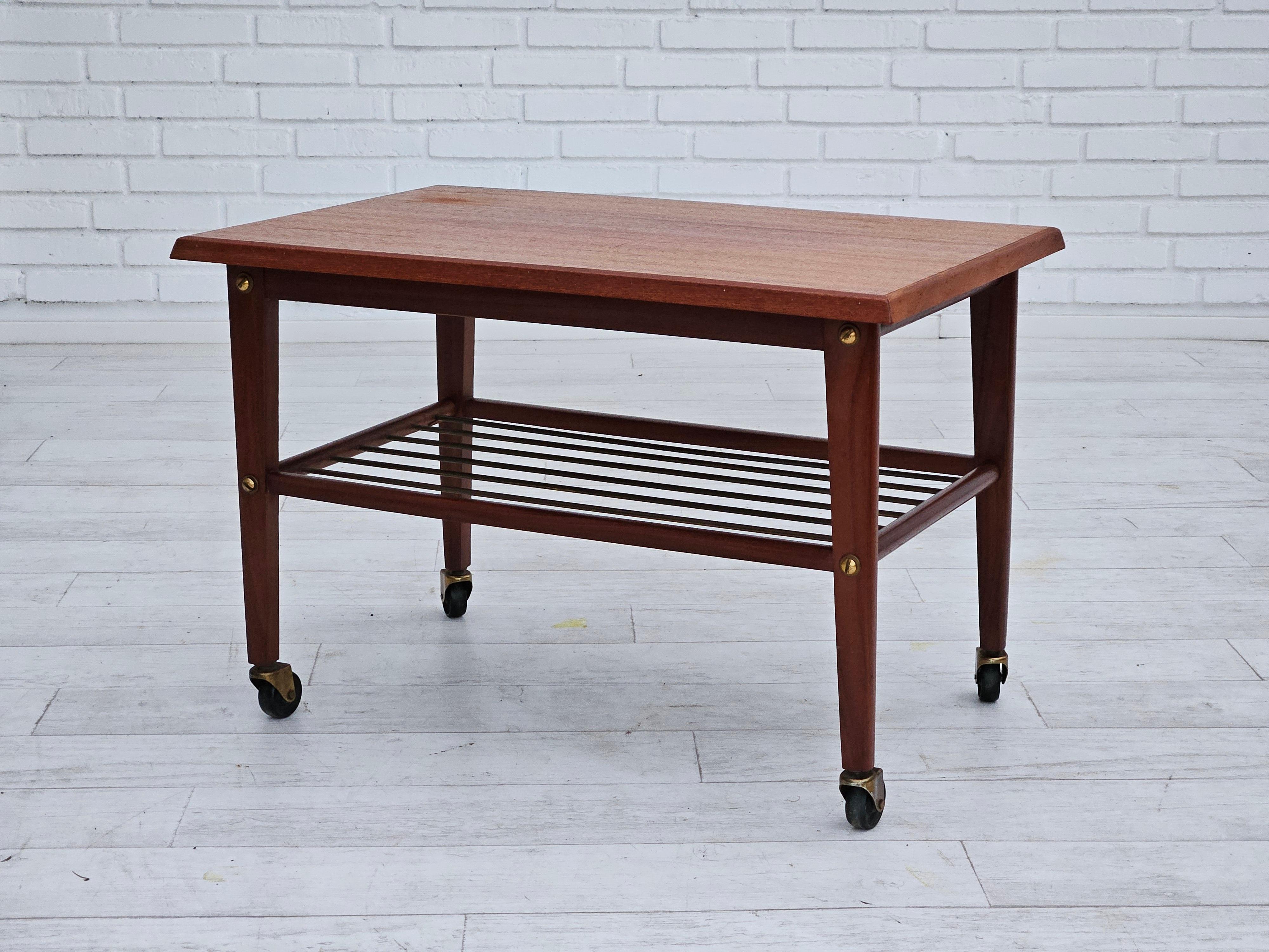 1970s, Danish coffee table on wheels. Teak wood, shelf with brass bars. Original good condition.