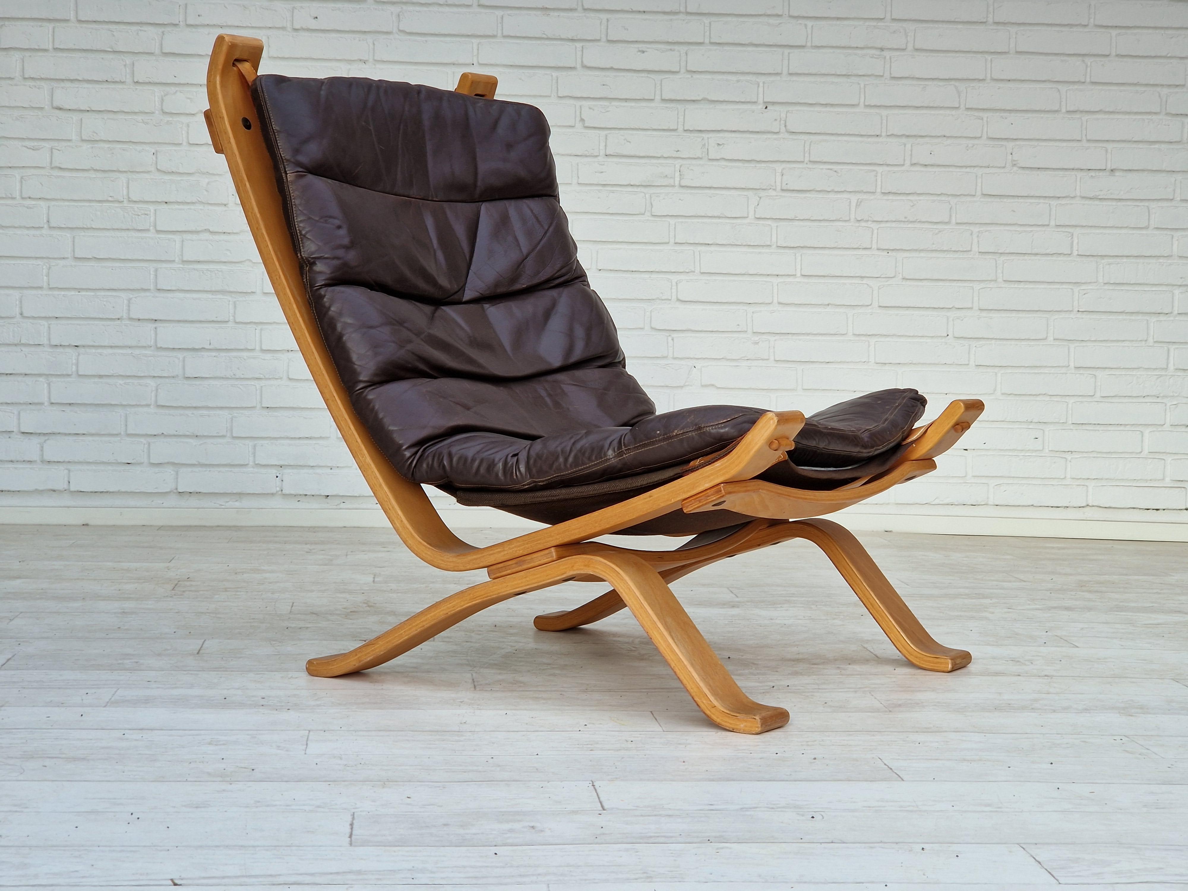 Années 1970, design danois de Bramin Møbler. Fauteuil en très bon état d'origine : pas d'odeur ni de tache. Cuir brun, contreplaqué plié, toile. Coussin amovible. Fabriqué par le fabricant de meubles danois Bramin Møbler vers 1970.
