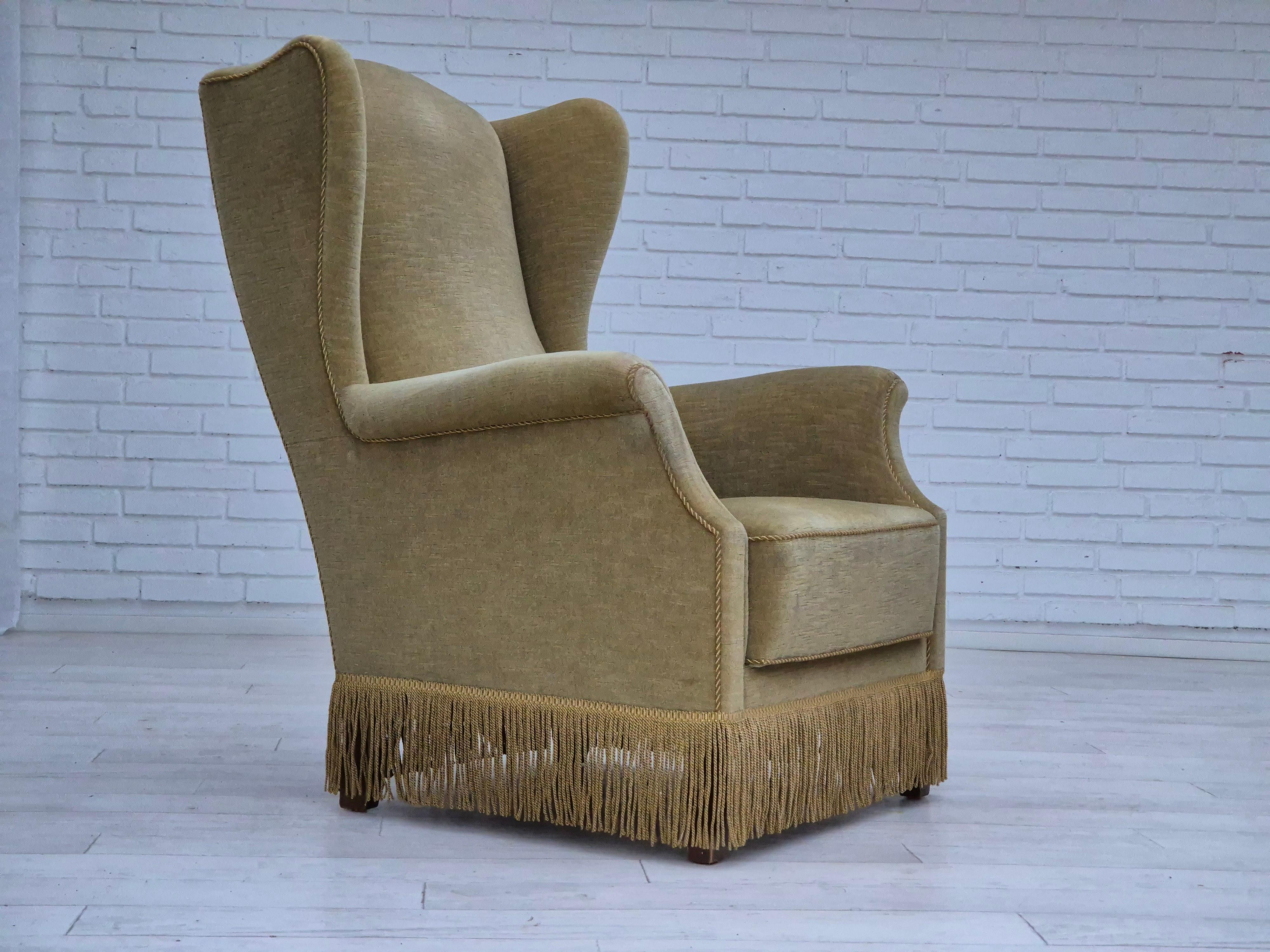 1970s, Danish design. Wingback armchair in original very good condition: no smells and no stains. Light green furniture velour. Beech wood legs. Springs in the seat. Manufactured by Danish furniture manufacturer in about 1970s.