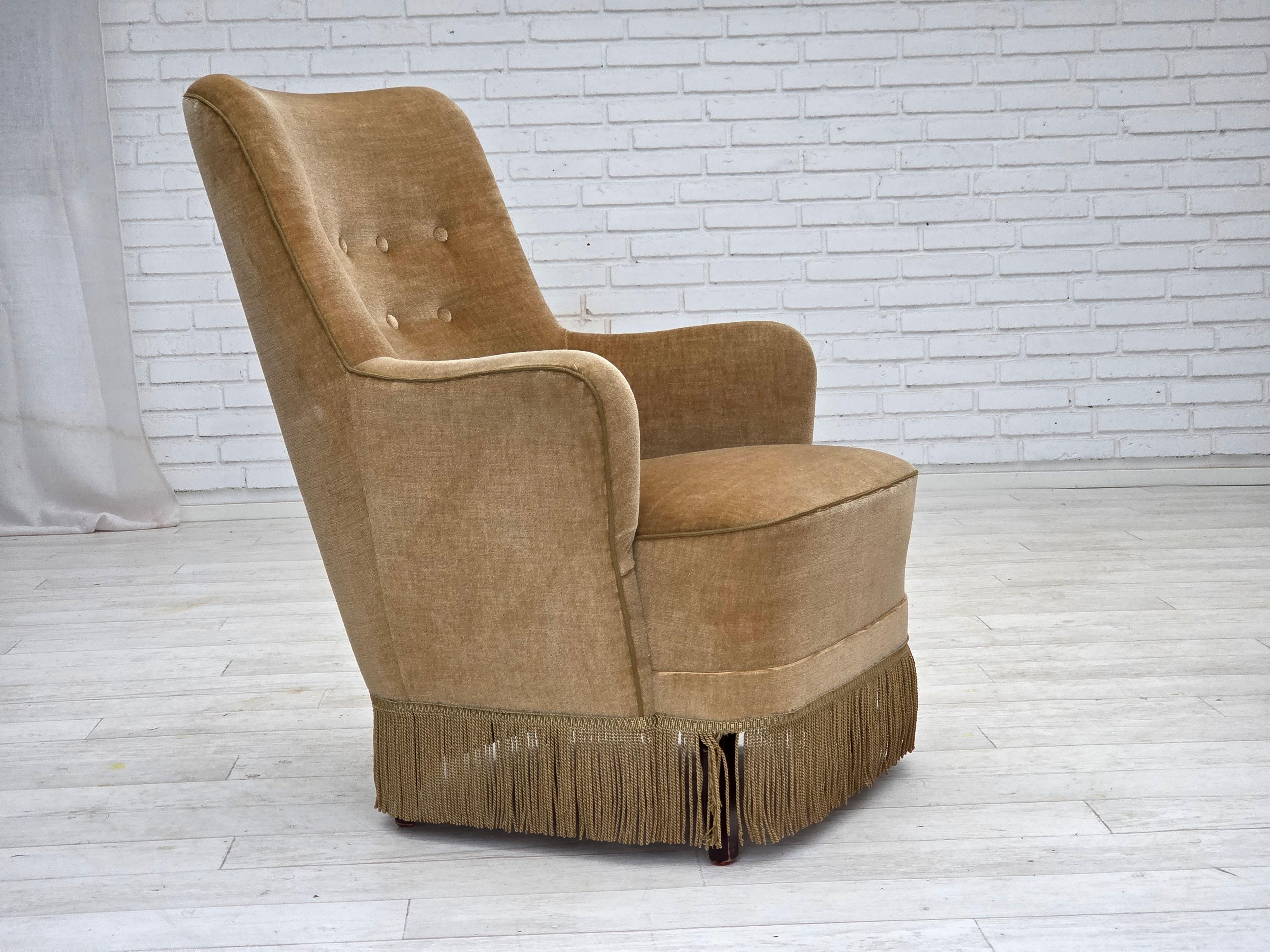 Poltrona danese con schienale alto degli anni '1970. Velluto da arredamento verde chiaro, molle nella seduta, gambe in legno di faggio. Condizioni originali molto buone: nessun odore, nessuna macchia e struttura stabile. Prodotto da un produttore di