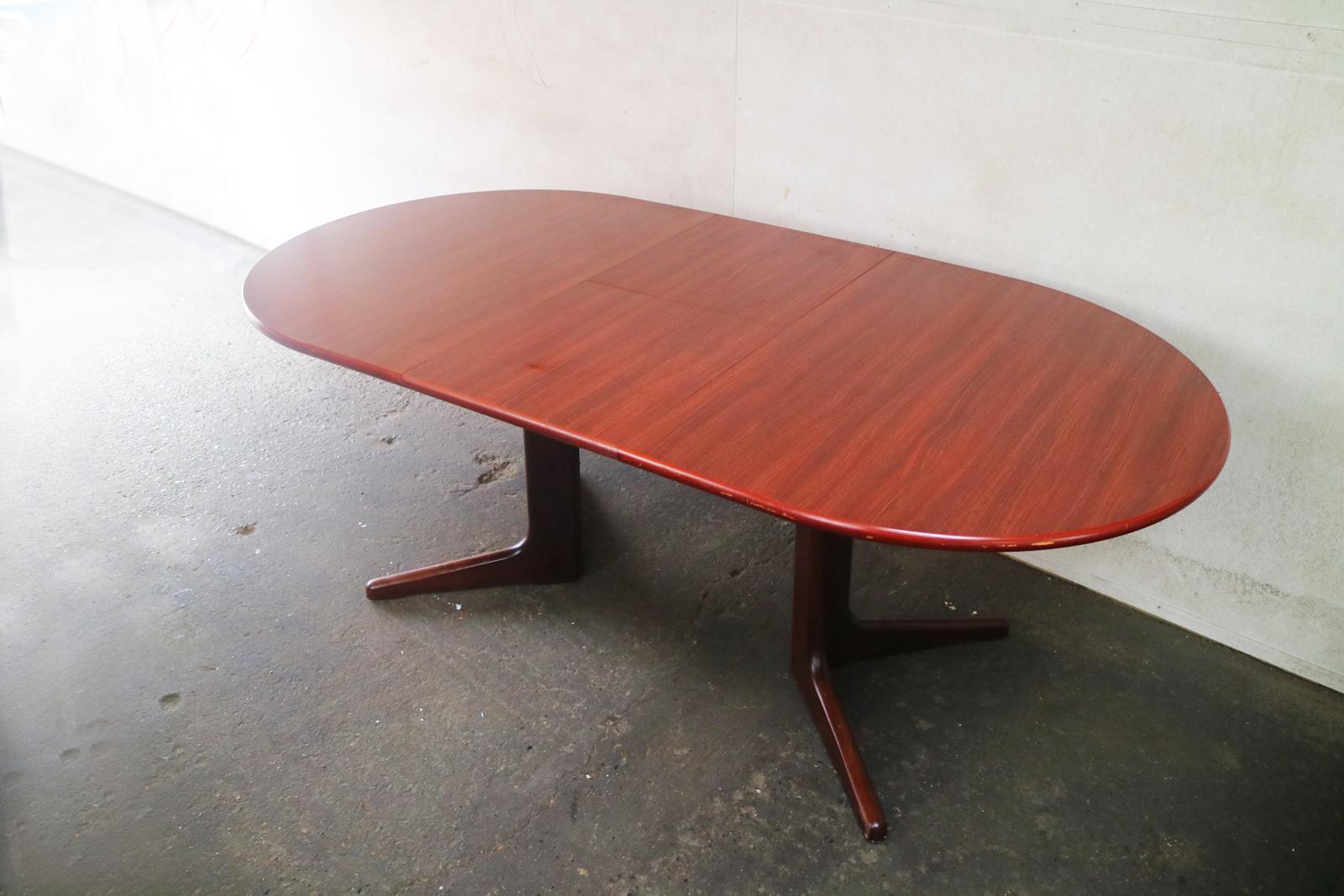 Extending dining table produced by Skovby in Denmark in the 1970s it features a fold in middle section. 

The dark teak wood shows beautiful grain, and is in great condition.

Sits on a pedestal base with splayed feet, legs are removable for