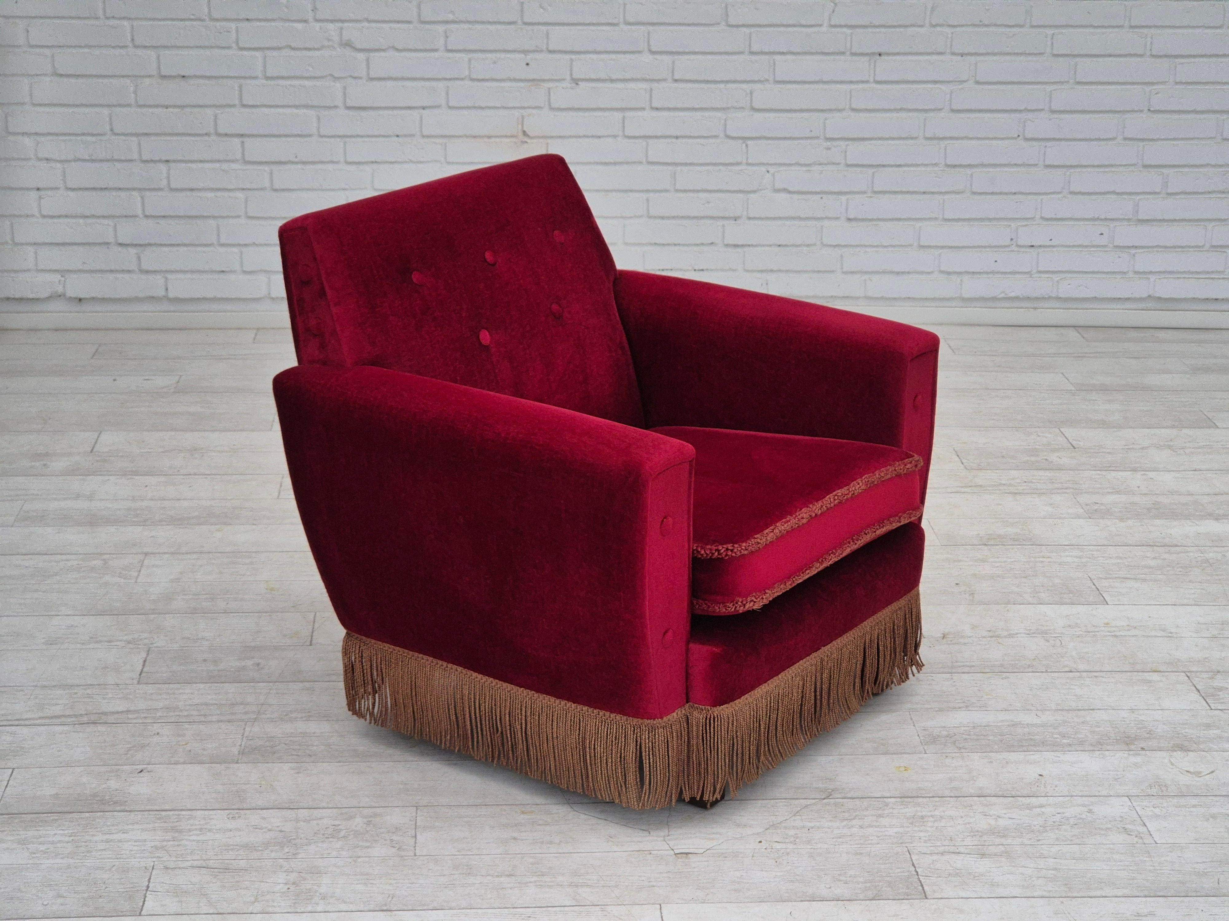 1970s, Danish lounge hair. Scandinavian design directly from Denmark. Original very good condition: no smells and no stains. Original cherry-red furniture velour. Ash wood legs. Springs in the seat cushion. Manufactured by Danish furniture maker in
