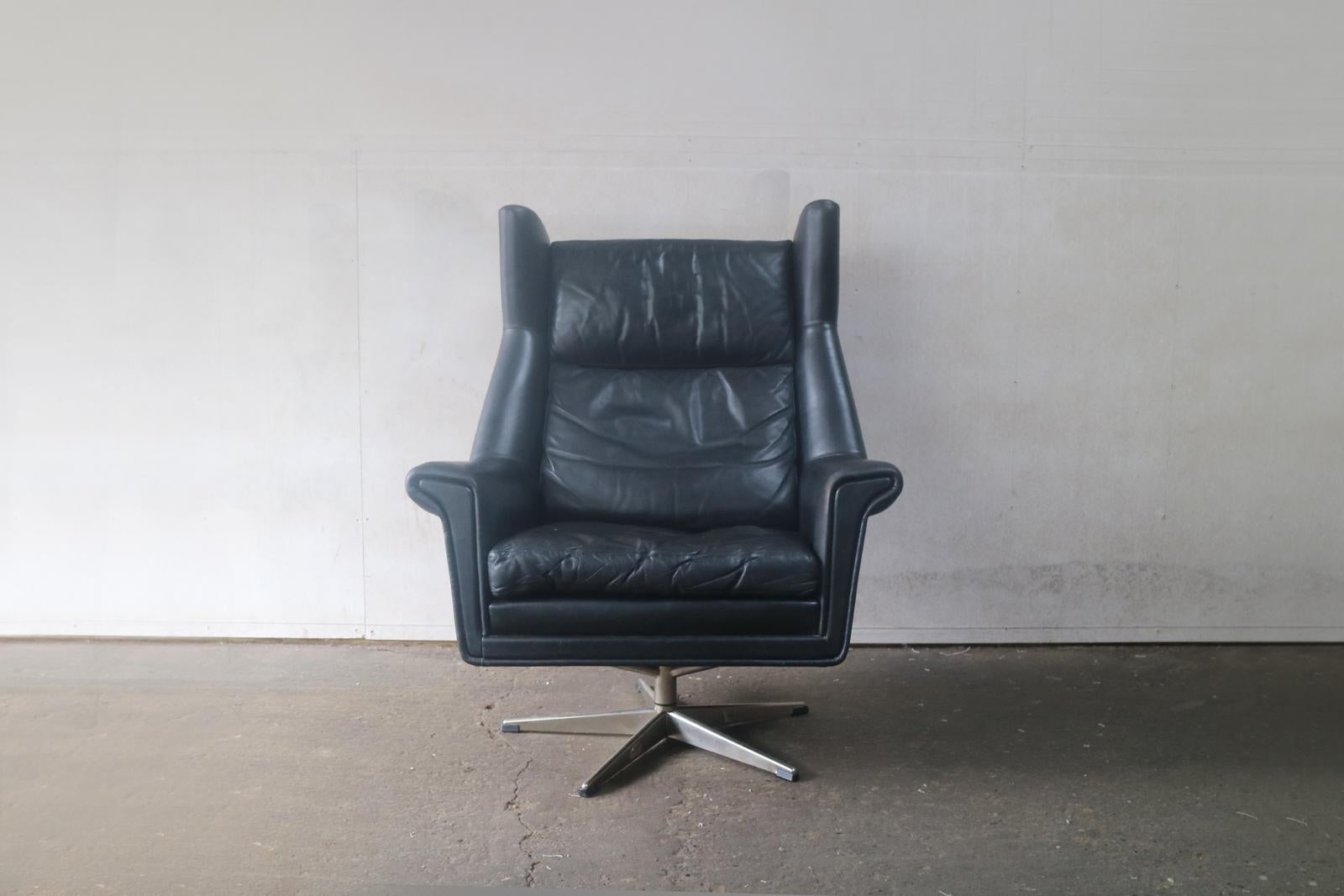 Super stylish Danish Mid-Century Modern armchair with the original black leather upholstery. Great angular design lines and the top of the chair has distinctive ‘wingtips’ fabulous piece.
 
