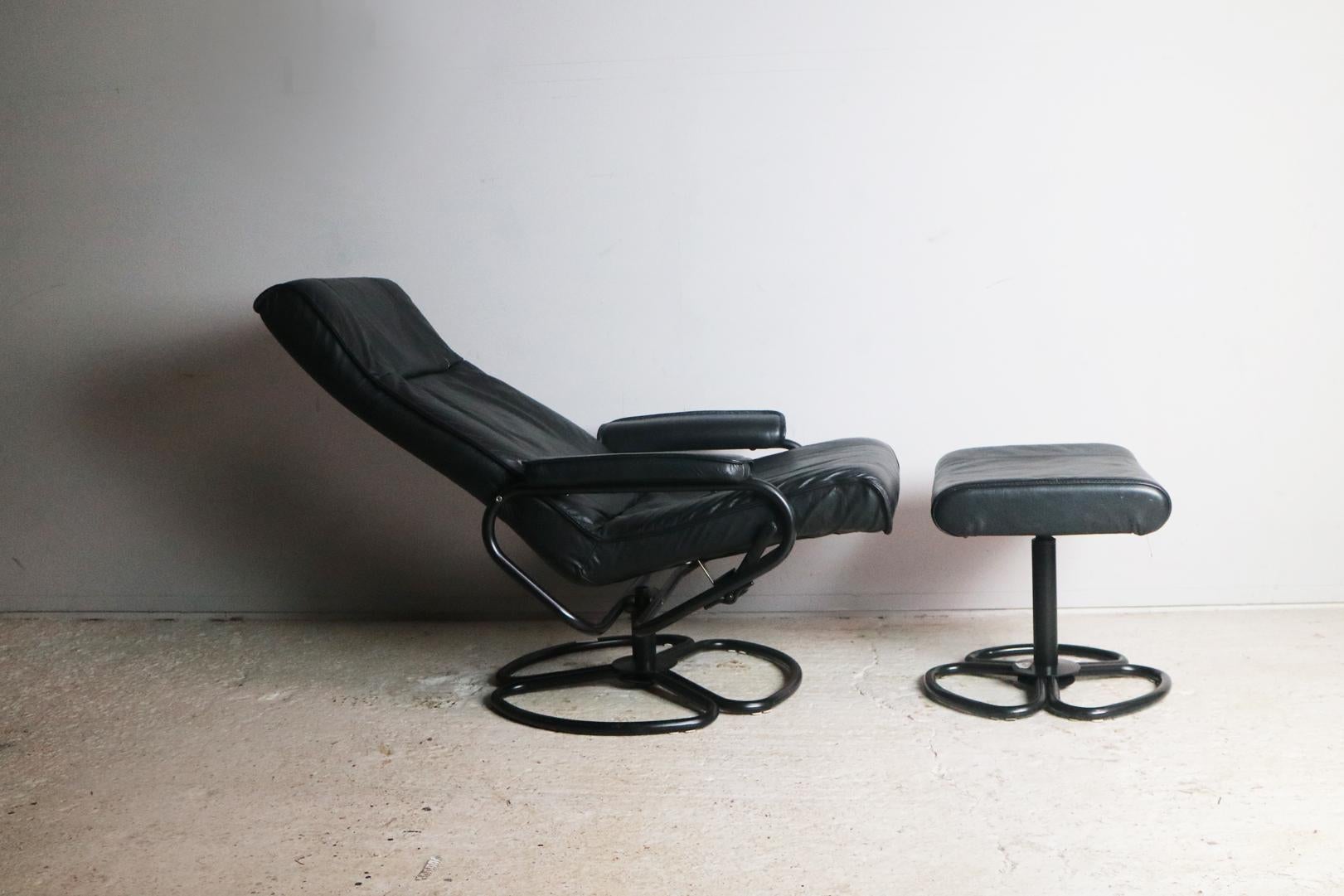 A Danish midcentury modern fully reclining lounge chair with matching footstool. Upholstered in the original black leather with black pointed steel frame.
 