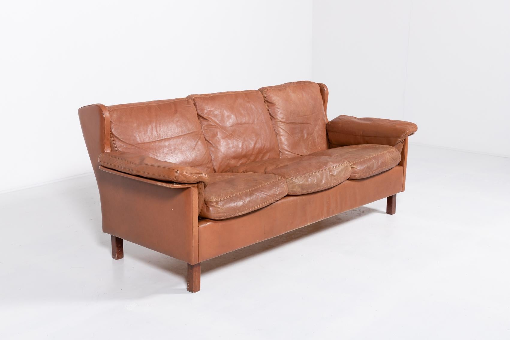 Danish Modern three-seat cognac leather sofa on varnished wood legs, loose cushions. Scandinavian classic style.

Condition
Fair, age related wear and patina.

Dimensions
width: 200 cm
depth: 80 cm
height: 78 cm
seat height: 44 cm