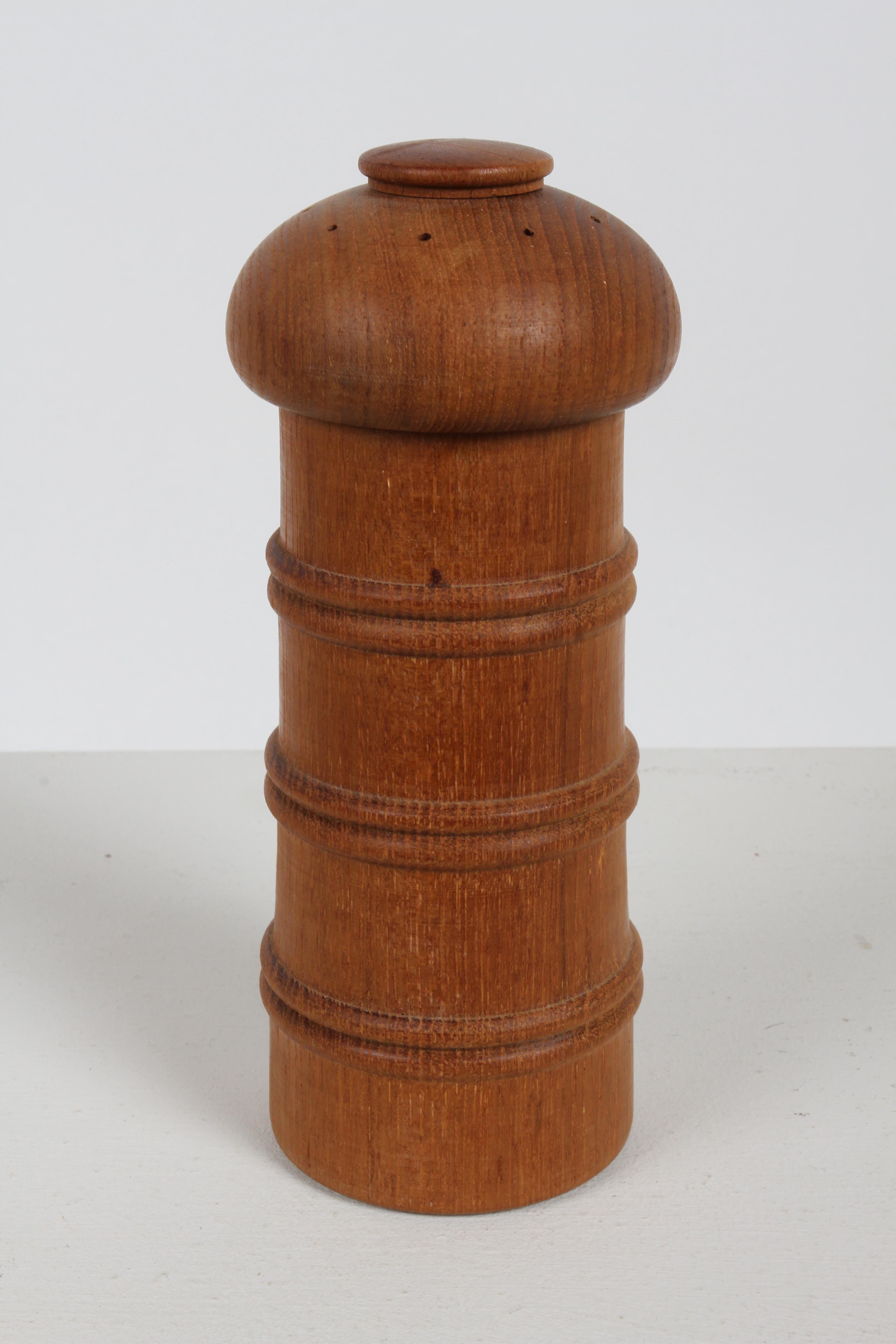 A 1970s Danish Modern Jens Quistgaard Salt & peppermill made of teak, tall form with raised rings. Stamped Dansk Designs Ltd Denmark JHQ. Nice original condition. 

Ground pepper comes out of the bottom when top turns and salt sprinkles from top