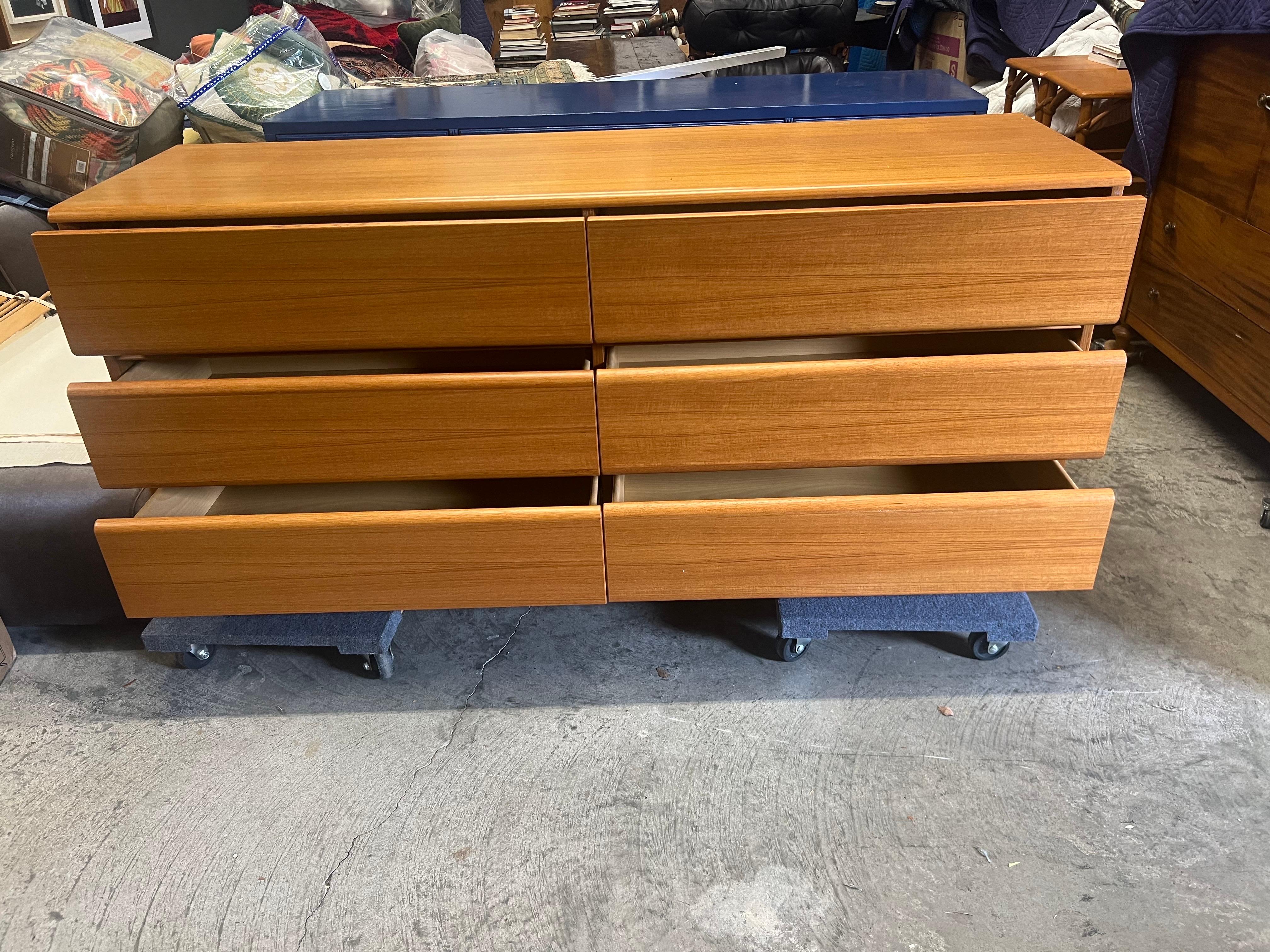 A vintage Mid-Century Modern teak double dresser from Denmark with beautiful wood grain. Both gorgeous and functional, this Scandinavian Modern chest of drawers dates from the 1970s. With 6 large drawers, it provides a ton of storage space. The