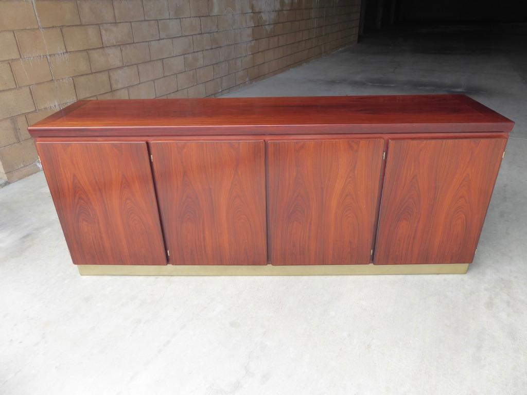 A sleek and sophisticated rosewood four-door sideboard/credenza by Danish manufacturer, Skovby. C. 1970s. Each of the doors is veneered in identical book-matched rosewood, with the same matched graining on the sides and top surface. The credenza is
