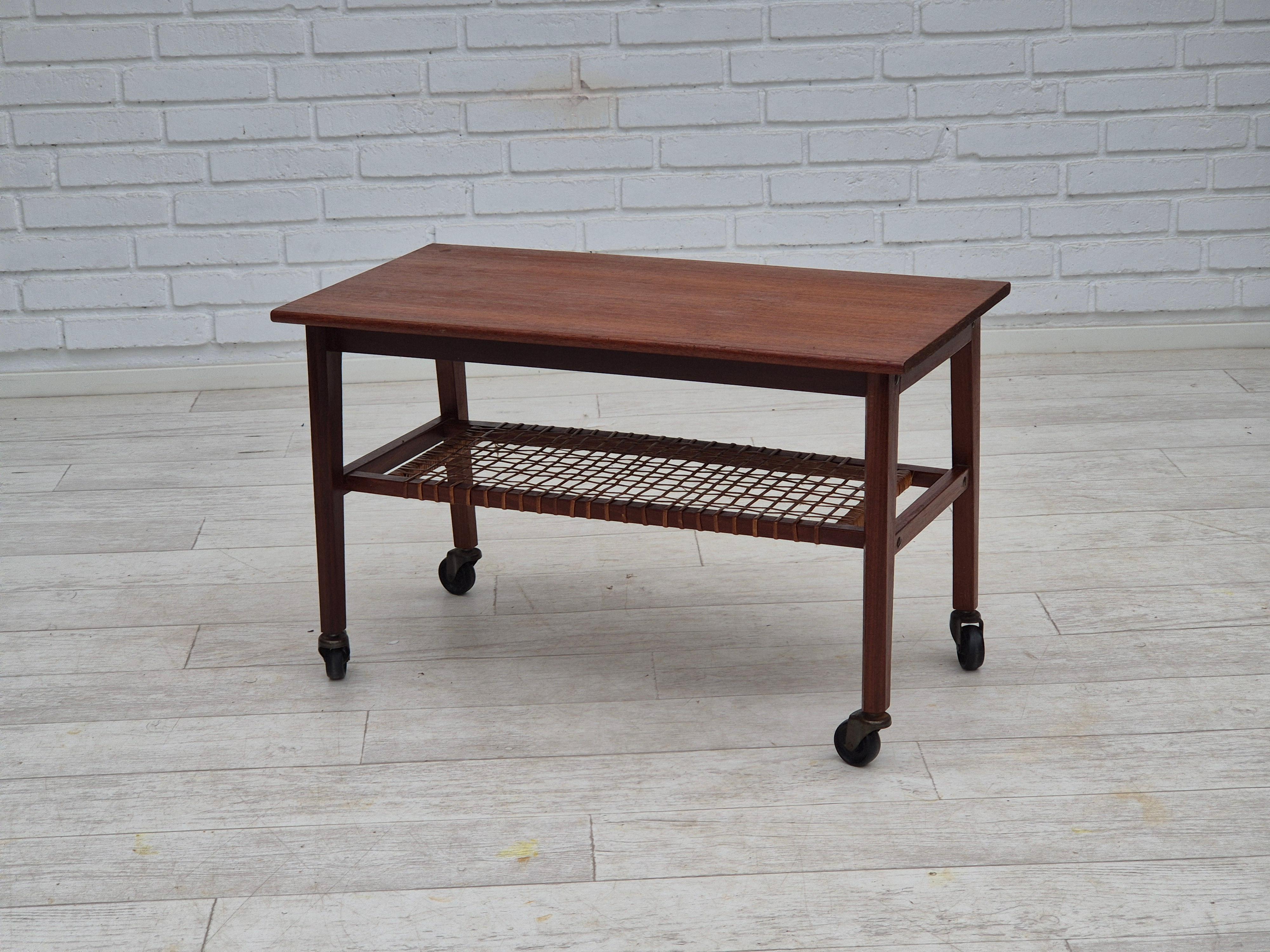 1970, table d'appoint danoise. Original très bon état. Bois de teck, rotin, laiton. Etagère en rotin. Fabriqué par un fabricant de meubles danois vers les années 1970. La table a été vérifiée par un artisan.