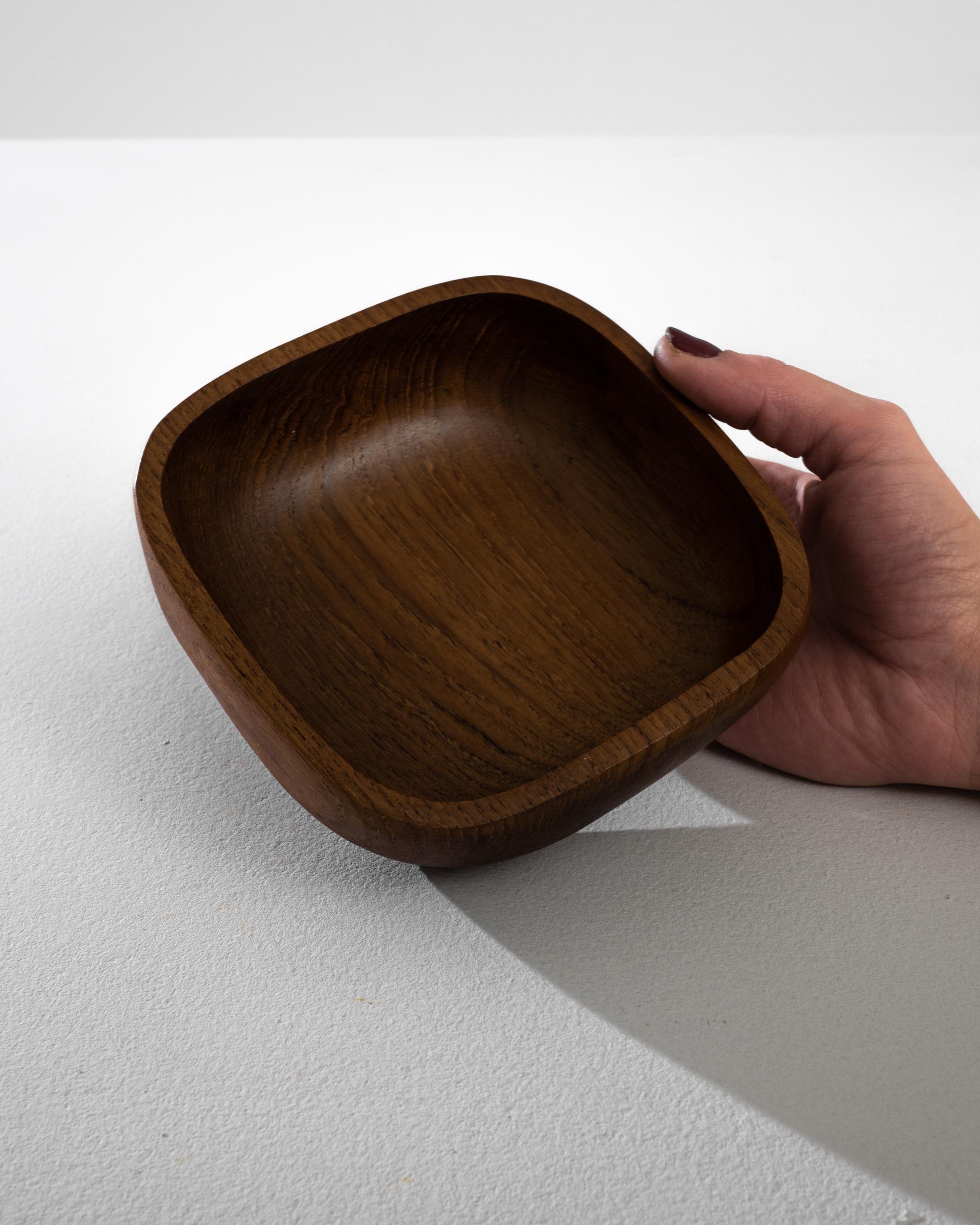 Immerse in the elegance of Danish design with this 1970s teak bowl, a piece that exemplifies the minimalist and functional ethos of the era. Each bowl, sold individually, is a testament to the beauty of simplicity, crafted from exquisite teak with a