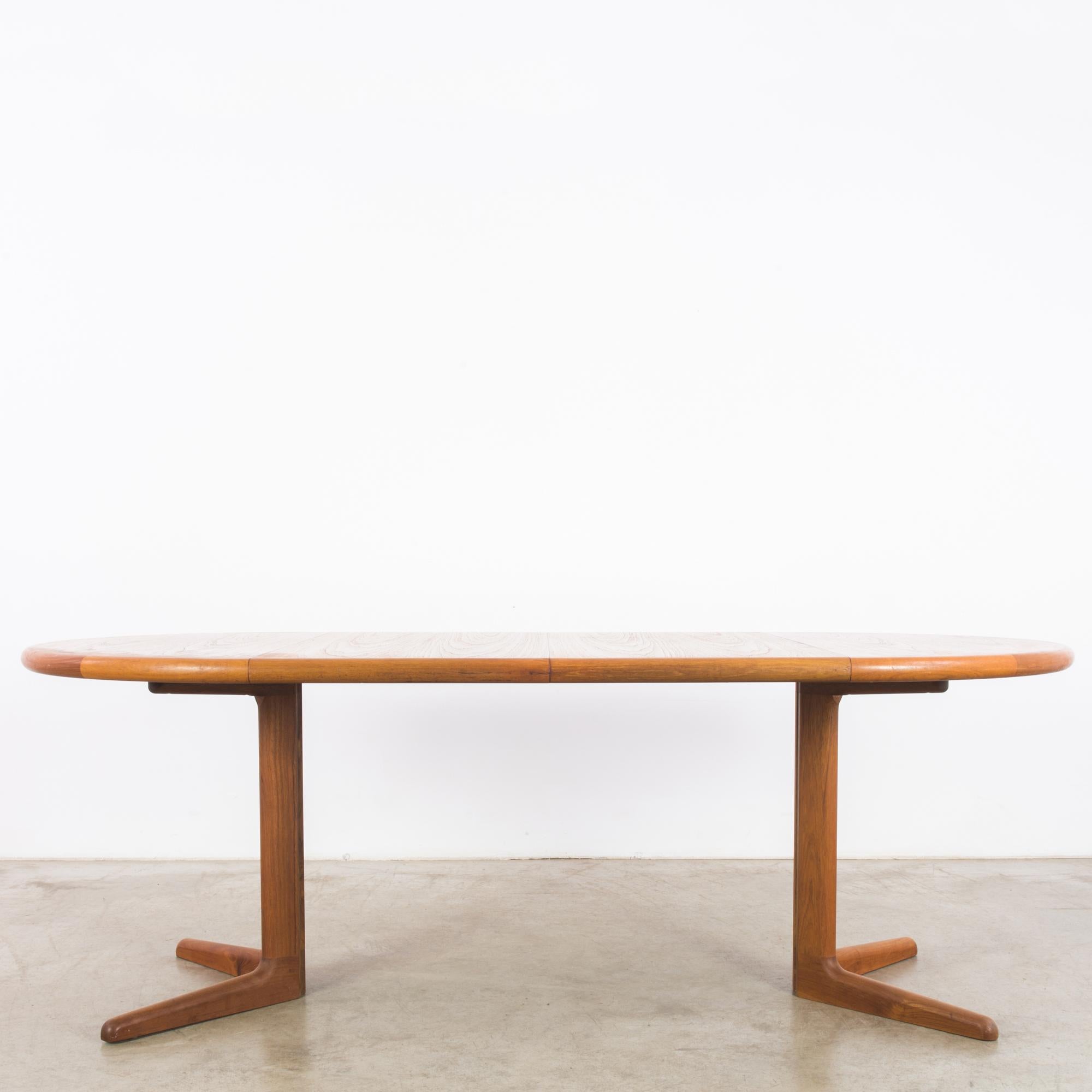 This teak dining table was made in Denmark, circa 1970. When fully extended, the table displays a stadium-shaped tabletop. It can be easily converted into a round table by removing two panels. This versatility and the use of high-quality teak