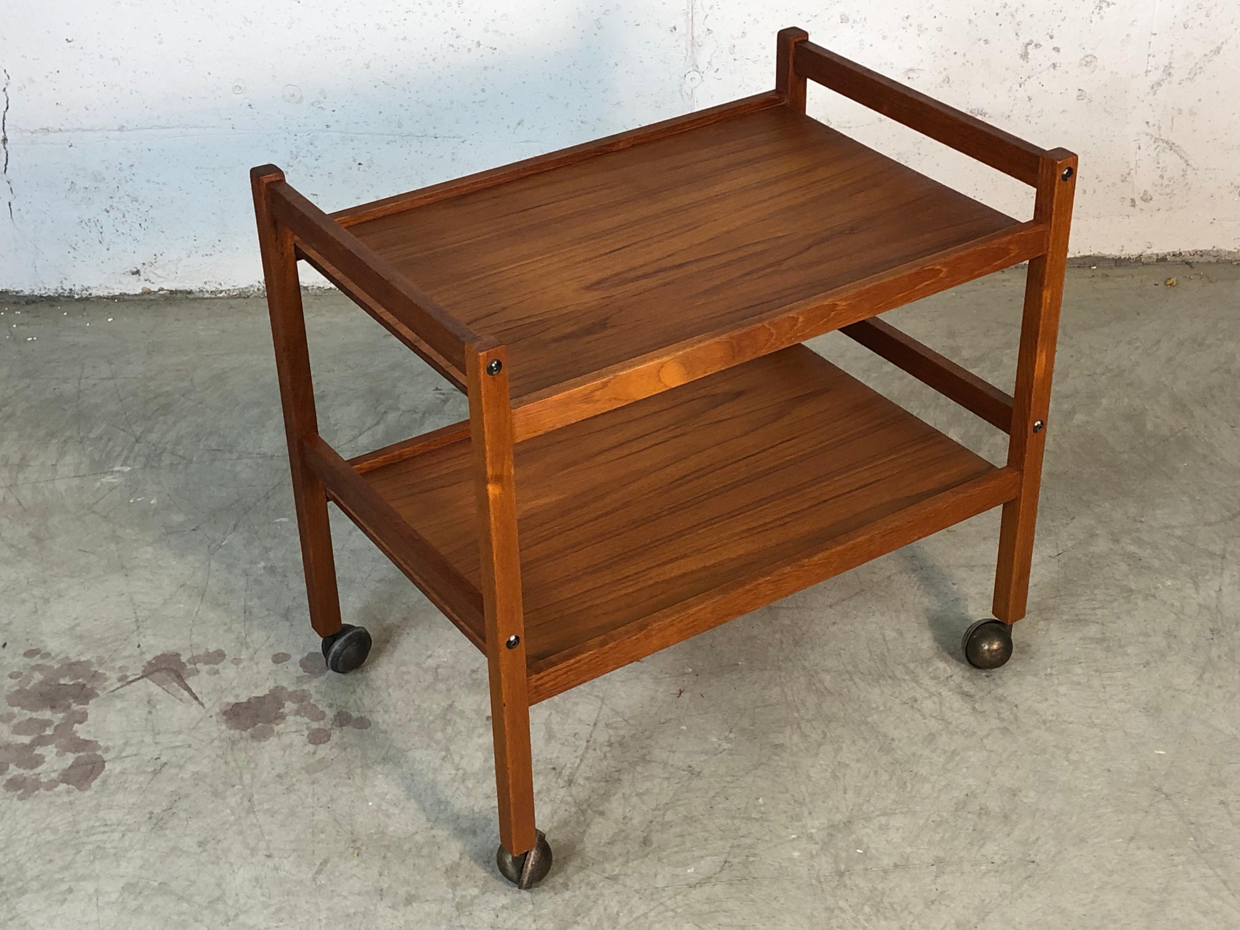 Vintage 1970s Danish teak two-tier rolling cart. The cart is in newly refinished condition. It is marked underneath, Furbo Made in Denmark.