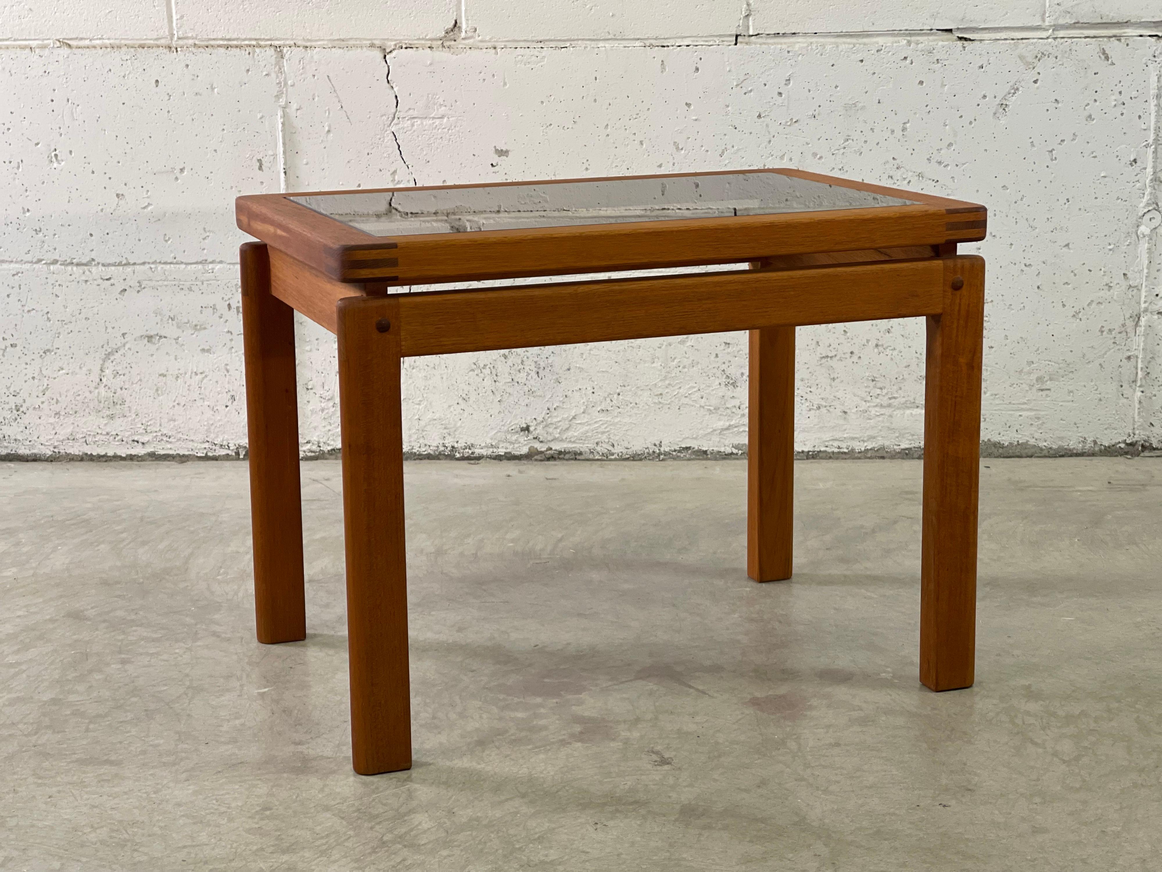 Vintage 1970s Danish teak rectangular side table with a smoked glass top. Nice exposed dovetailed joints. Marked underneath.