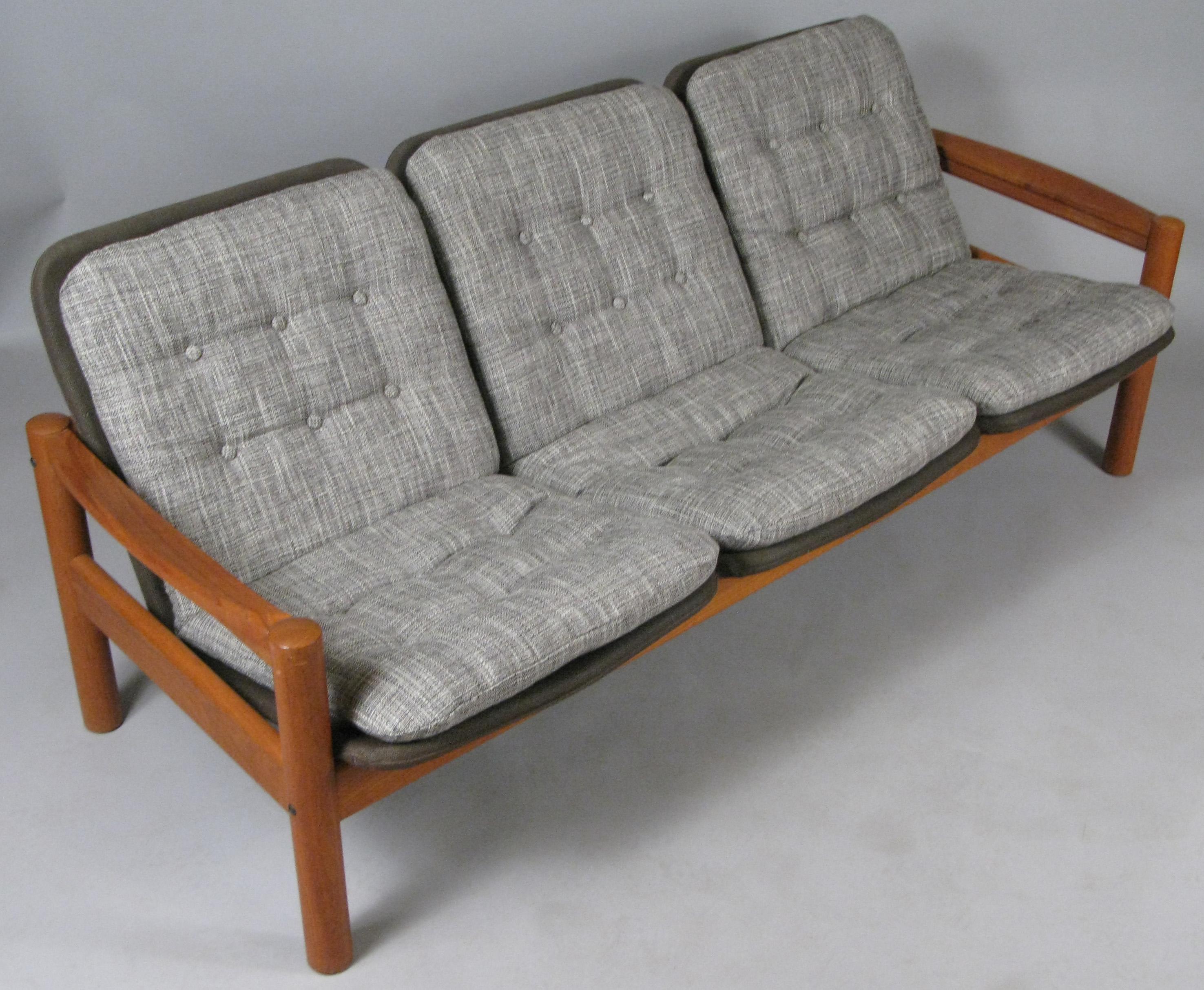 A very handsome solid teak vintage 1970s three seat sofa made by Domino Mobler. With it's original brown linen covered seat frames, and newly upholstered button tufted seat covers in a woven grey and cream. This listing is for the 3 seat sofa only.