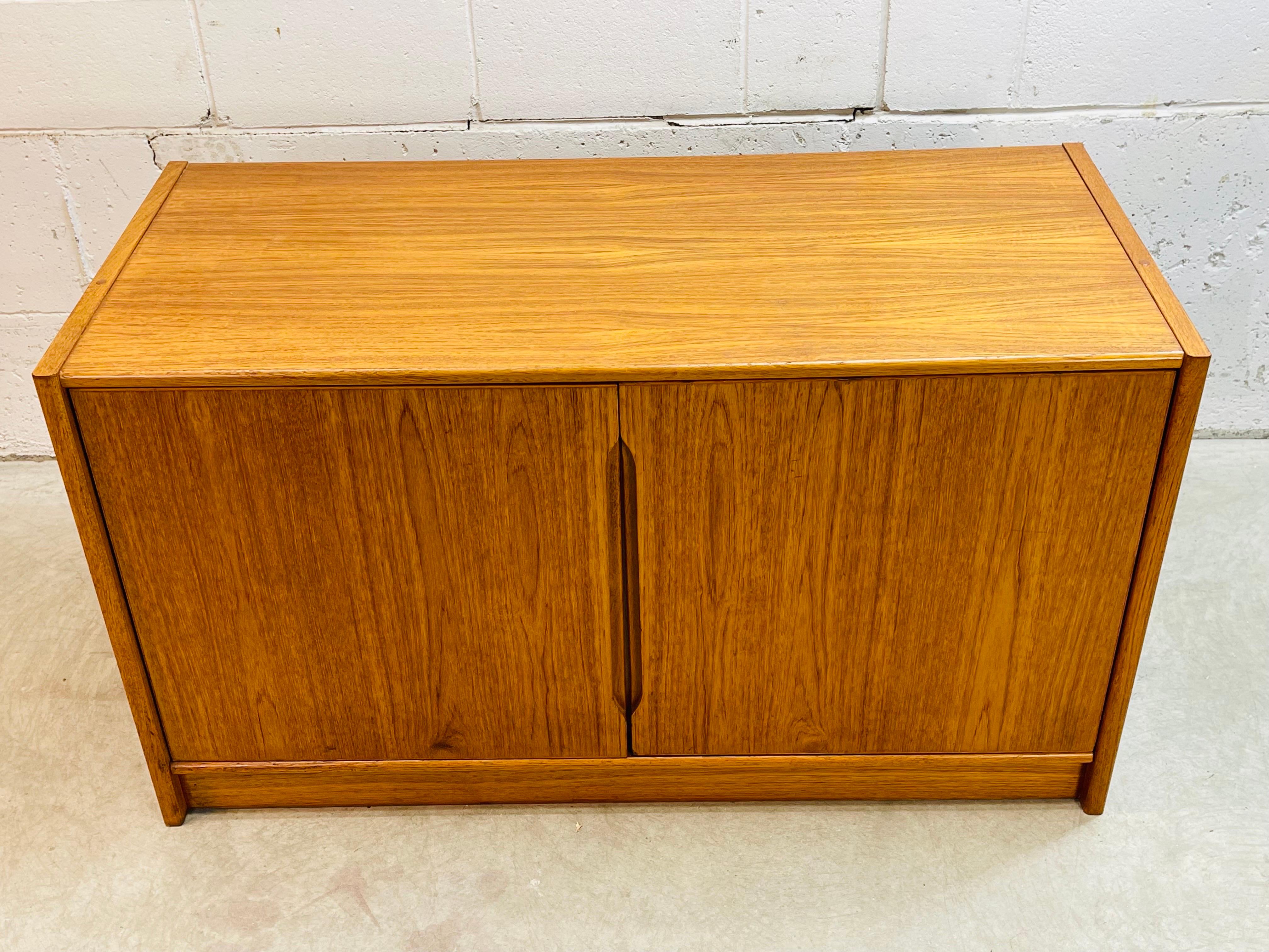 Vintage 1970s Danish teak wood storage cabinet with adjustable shelving. Solid and sturdy with doors that operate perfectly. A large storage cabinet that could hold a sizable TV or entertainment center on top. Newly refinished condition. Marked on