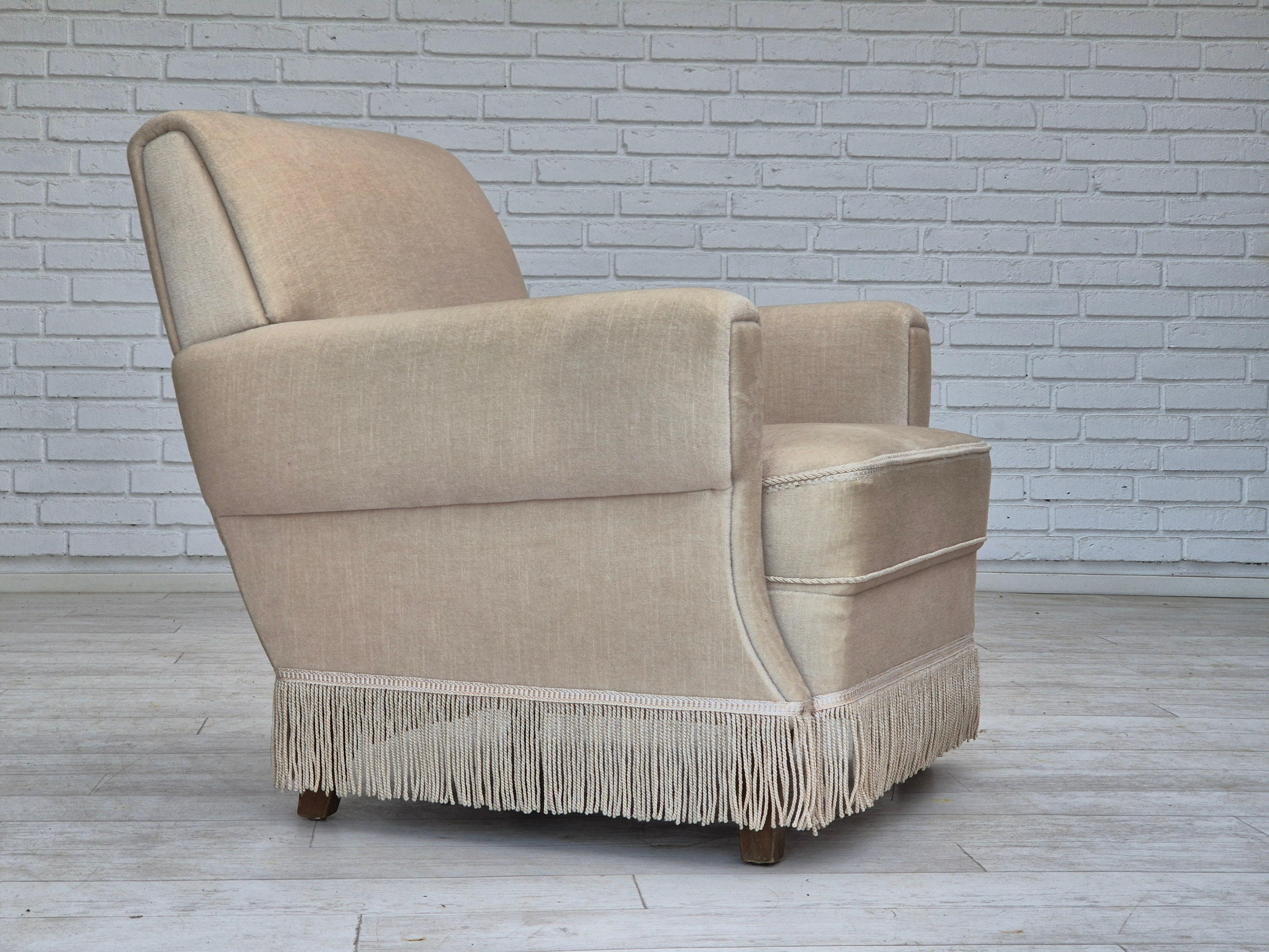 1970s, armchair in original good condition: no smells, no stains. White/light beige furniture velour, ash wood legs, springs in seat. Manufactured by Danish furniture maker in about 1970s. The chair was checked by craftsman.