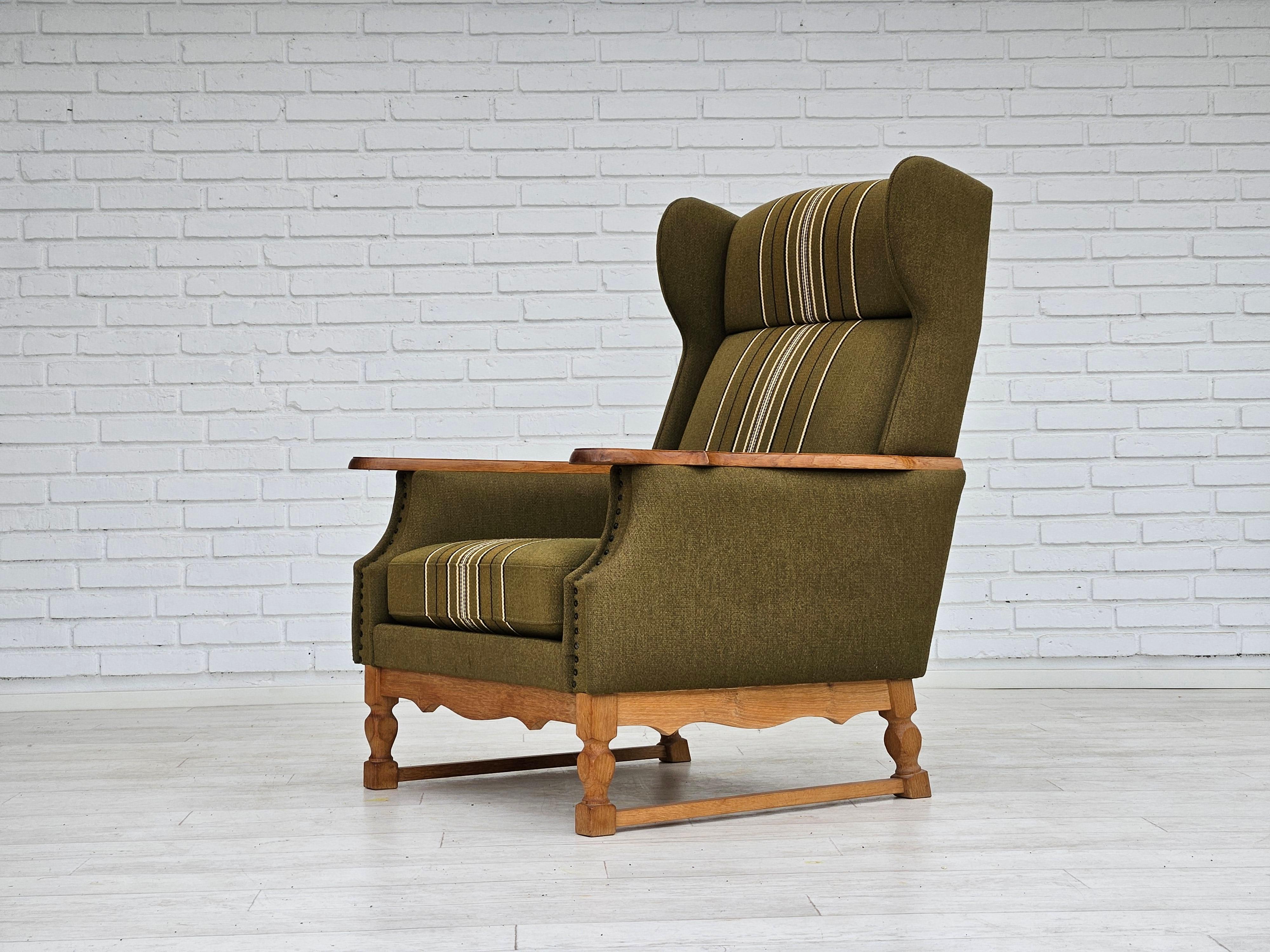 1970s, Danish wingback chair. Original very good condition: no smells and no stains. Green furniture wool, oak wood. Springs in the seat cushion. Manufactured by Danish furniture manufacturer in about 1970s.