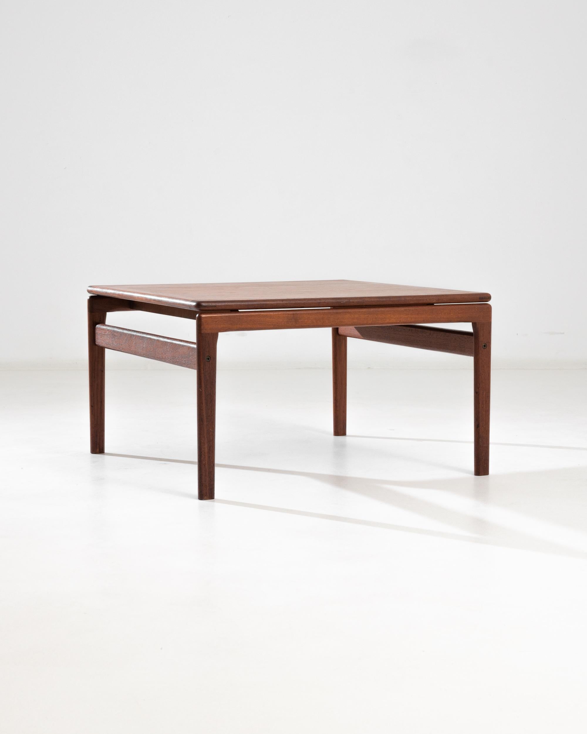 A mid-century wooden coffee table from Denmark. With half-lap corner joints, subtly tapered legs, and floating table top, this side table is a fine example of understated yet exquisite Danish furniture-making. Its minimalistic design and gleaming