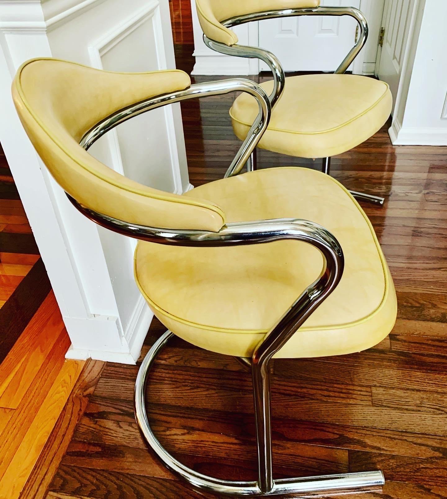 Stylish pair of vintage tubular chrome and naugahyde cantilever chairs by Daystrom. Perfect for dining, side or office chairs. Comfortable and sturdy, this pair has been well care for. The seat and back are in a buttery shade with slight contrast