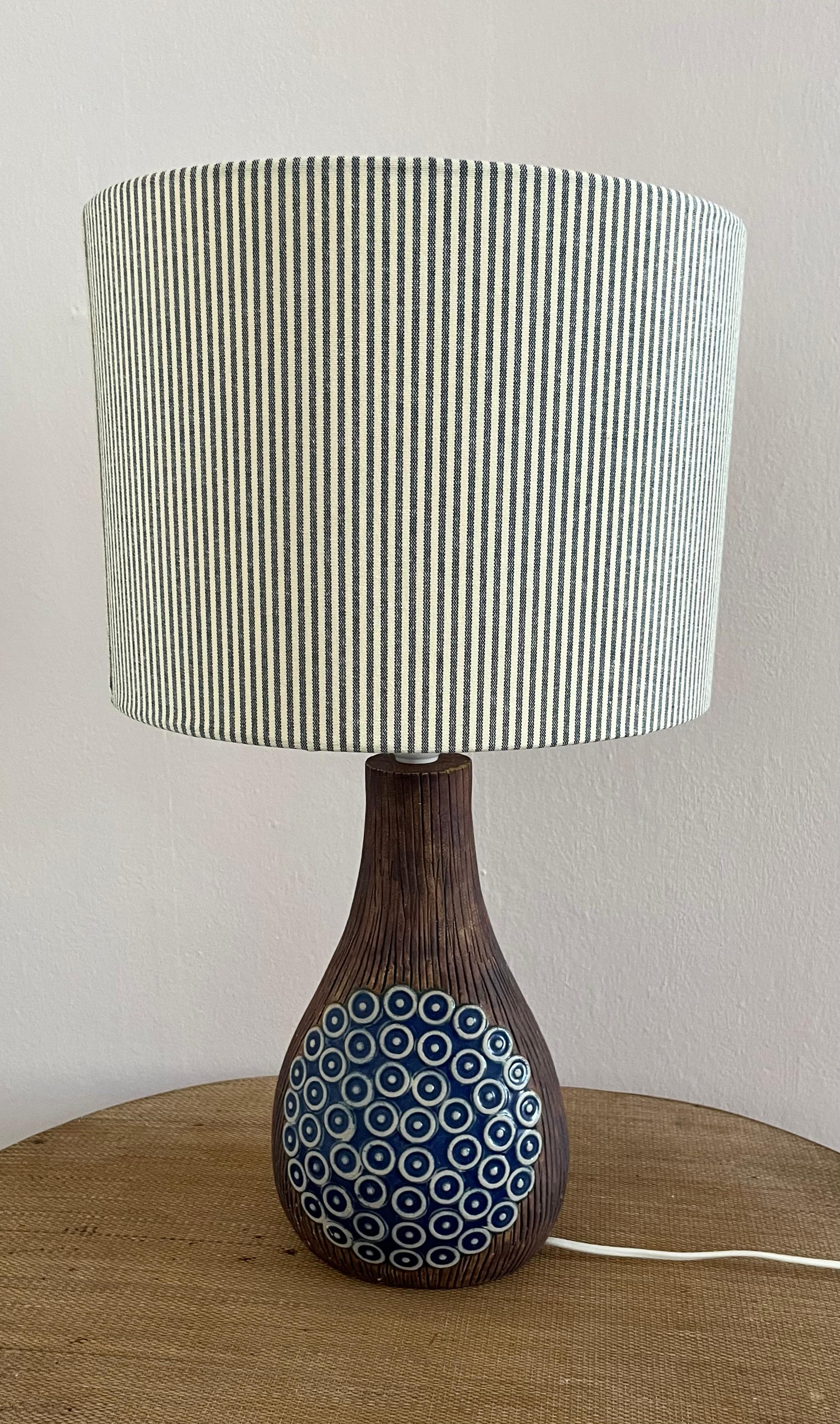1970s decorated ceramic table lamp from Swedish Ego Stengods.
Made in the 1970s, this matte ceramic table lamp has a glossy blue and white glazed decoration on both sides. Made by Ego Stengods in Sweden. European wired with socket for E-27 light