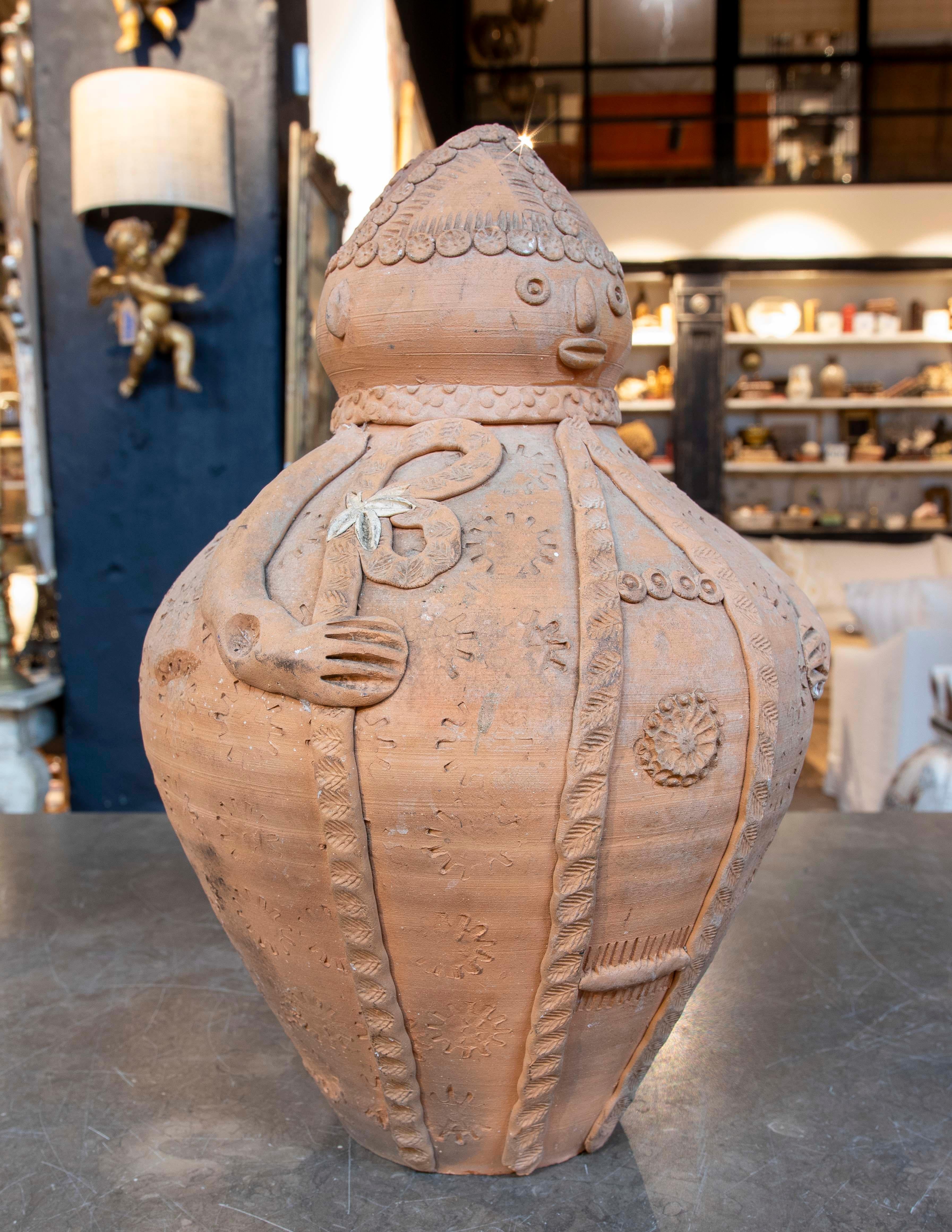 A unique handcrafted clay piece in the shape of a traditional figure, richly decorated with relief details and symbolic motifs. Its charming expression and meticulous ornamentation give it a charming character steeped in history. Ideal as a