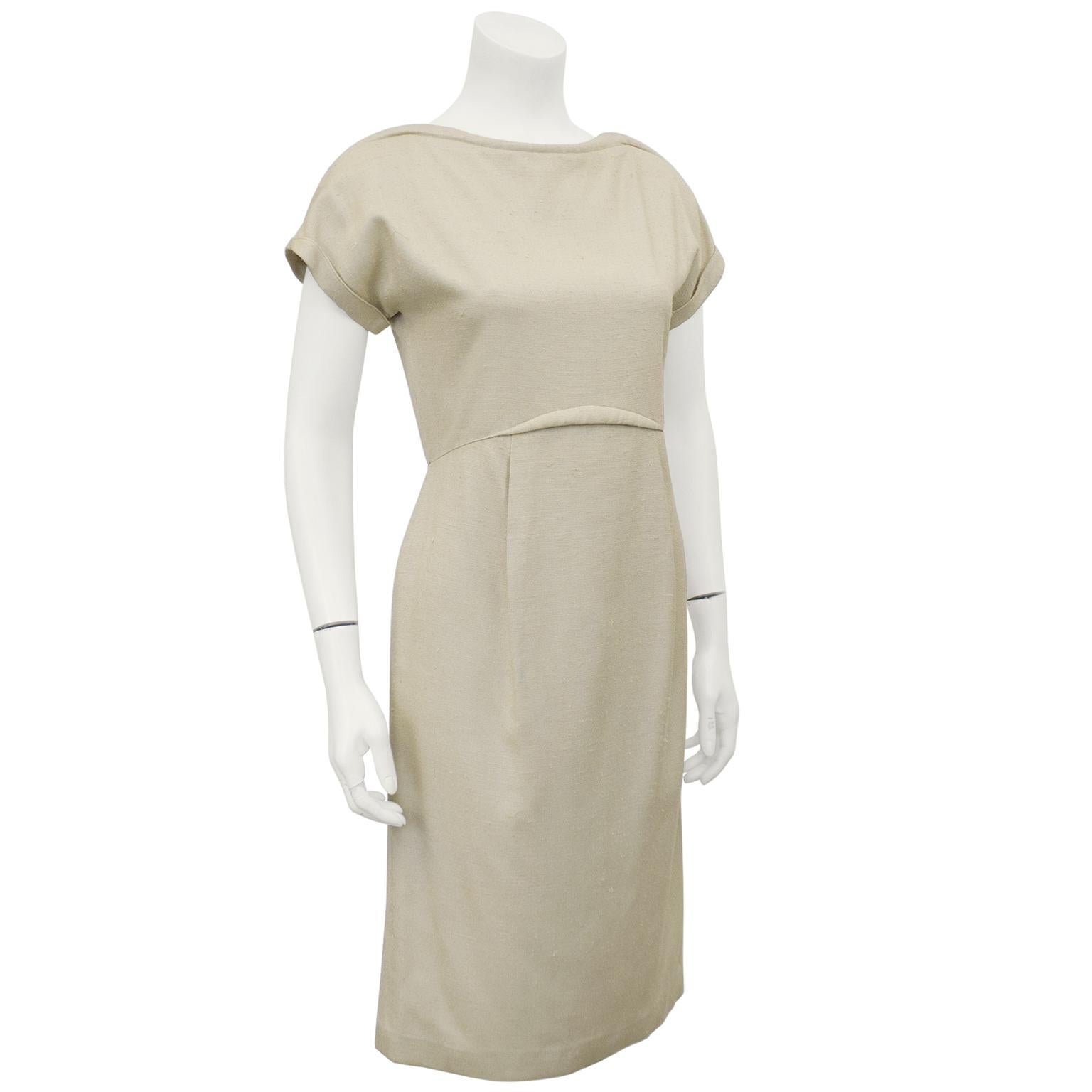 1970's beige raw silk cap sleeve demi couture Geoffrey Beene day dress. Stunning in its simplicity with a unique wave shaped welt at the neckline and mirrored ever so slightly at the elevated waistline. Undarted upper bodice with a short cuffed cap