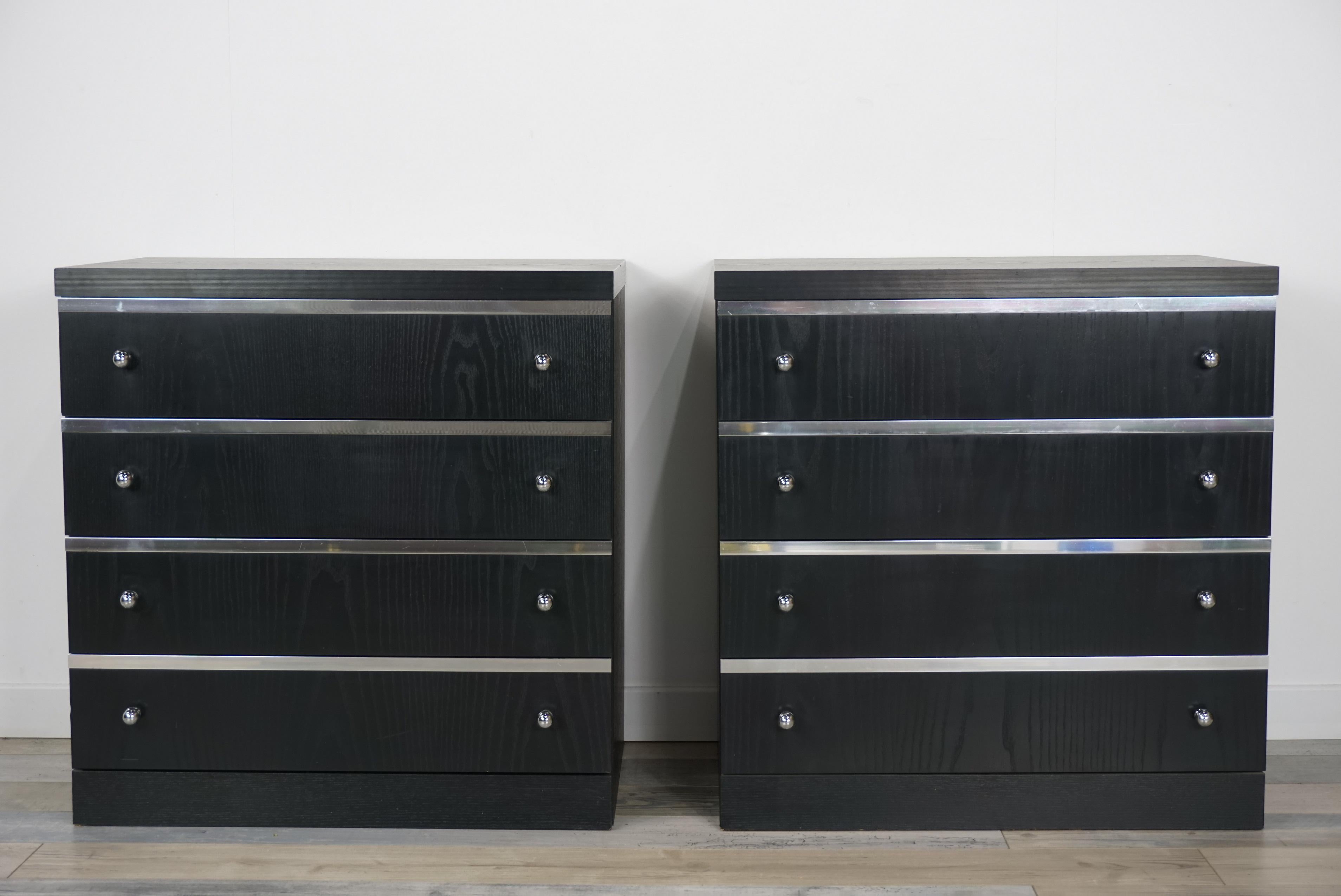 Pair of bedside tables or adorable chests of drawers in black wooden and chrome with sober lines and Minimalist design of the 1970s offering beautiful storage spaces, four large drawers which have for each their facade subtly crafted by a chrome