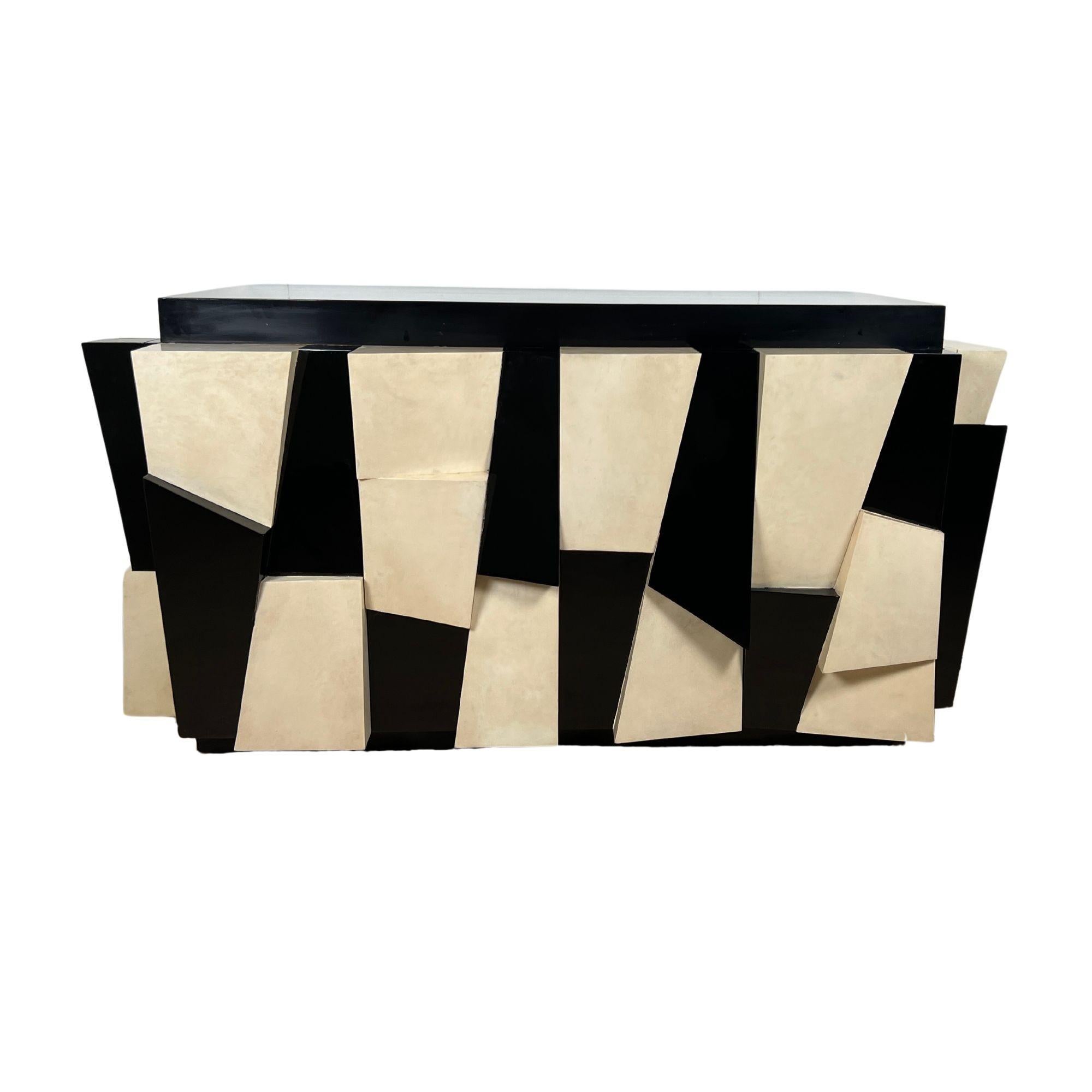Extraordinario Aparador, Armario o Consola de Diseño Vintage de los años 70 al Estilo de Paul Evans fabricado en Madera, Pergamino y Laca.
Exterior con secciones esculpidas en relieve de madera lacada en negro y pergamino de color crema lacado