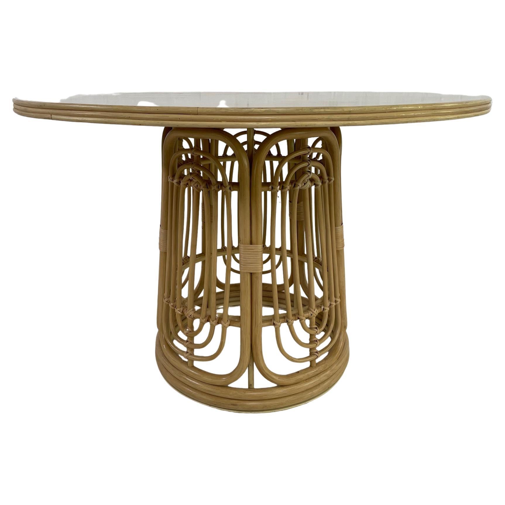 Italian 1970s design style round pedestal table consisting of a metal structure with graphic and aerial rattan base adorned with a round wooden tray.