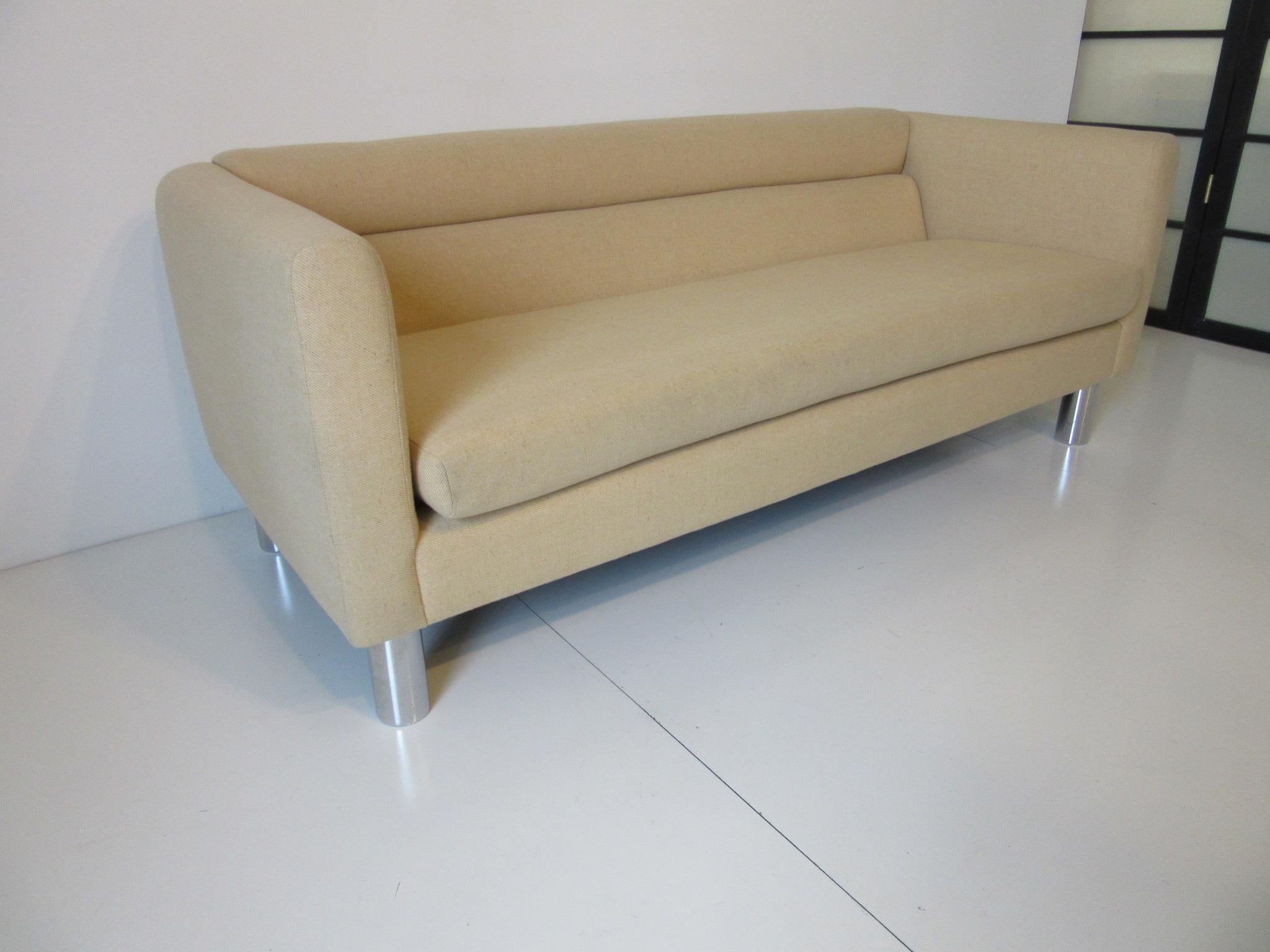 A vintage 1970s sofa or loveseat with fitted back and loose bottom cushion with chromed round tube shaped metal legs and original wool blended fabric, retains the manufactures label and ticking by David Edward Furniture Ltd. A very modern