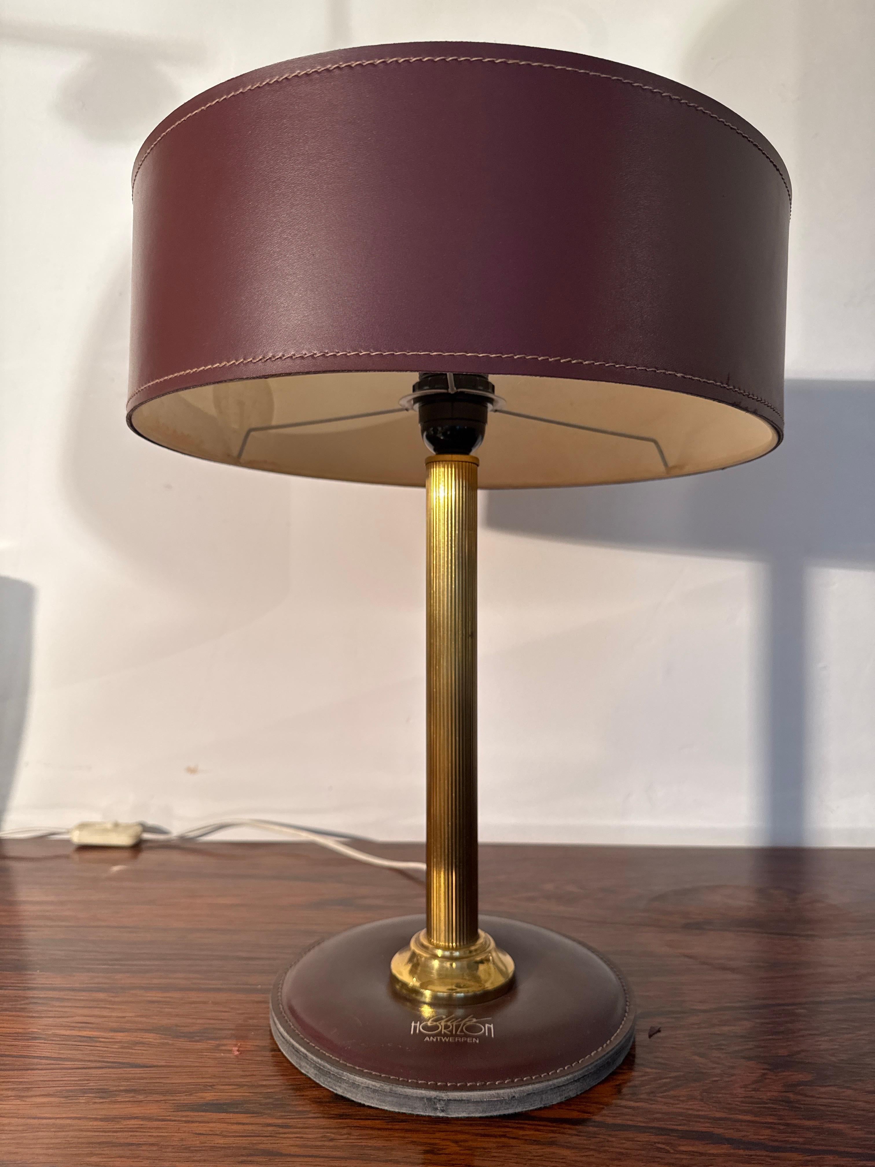 Classic beautiful desk lamp designed in red leather and brass accents featuring the logo of the Antwerp club attributed to Jaques Adnet French designer in the 60s and 70s.
The lamp provides a warm, atmospheric light directly on the desk and as an