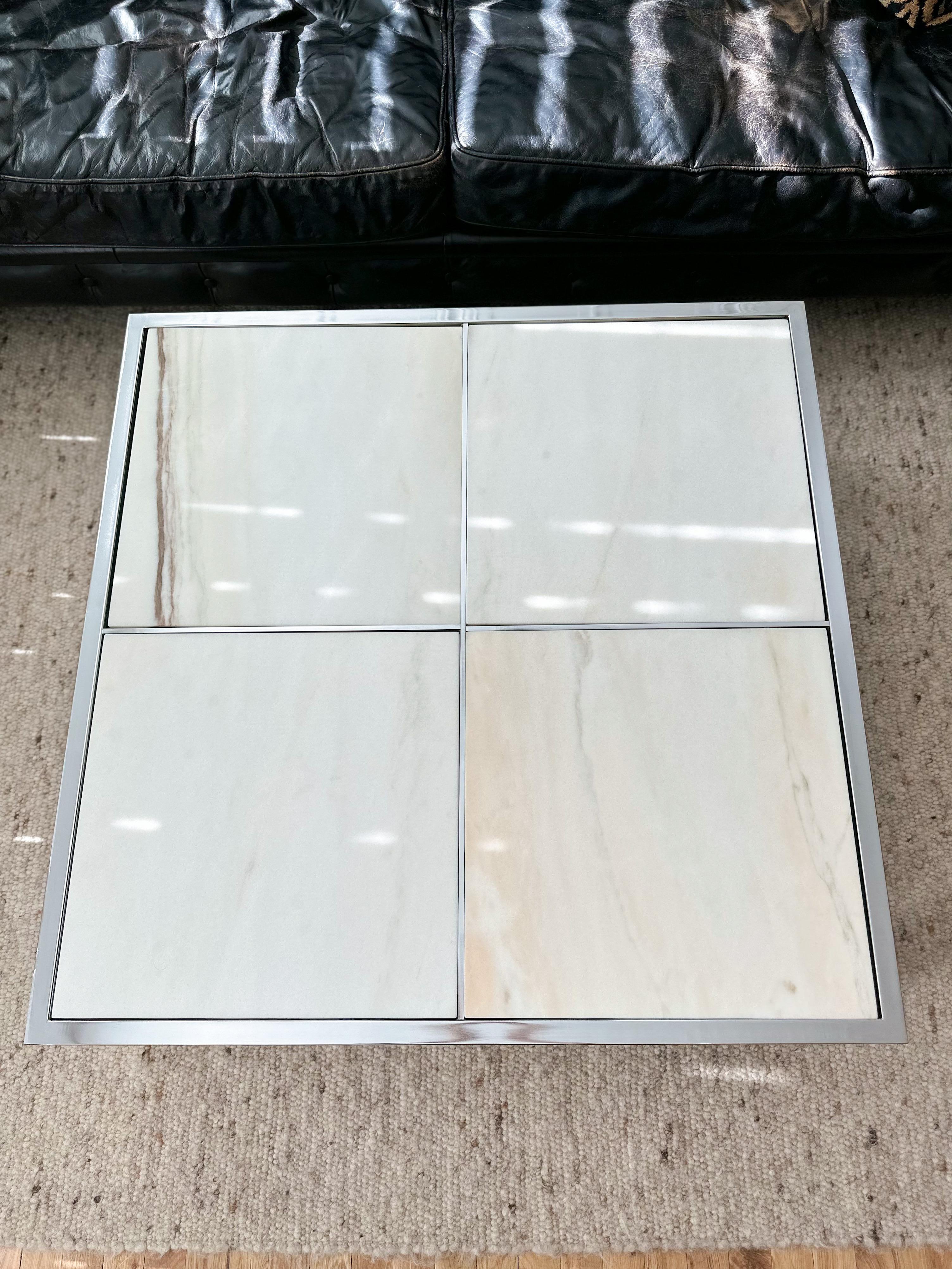 Timelessly elegant chrome and marble square coffee table by Design Institute of America (DIA), c.1970s. Thick chromed steel frame supports four large Portuguese marble slabs with white, gray, and beige tones. Slabs sit comfortably within the