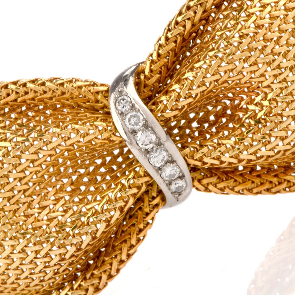  This vintage  diamond bracelet is crafted in 18-karat yellow gold, weighing 79.4 grams and measuring 7.50” around the wrist x 34 mm wide. Made to simulate fabric this flexible bracelet features a braided yellow gold cinched by four white gold