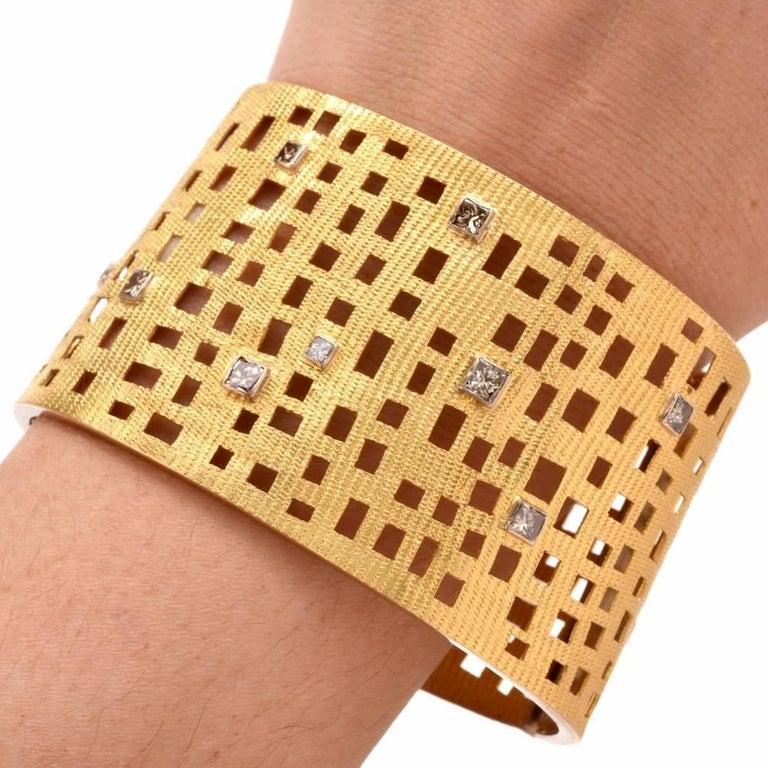 This aesthetically fascinating wide bracelet is rendered in 18 karats matted and finely textured yellow gold, weighing 73.9 grams and measuring 7 inches around the waist and 1.75 inches wide. Enriched with ornate asymmetric perforations, the