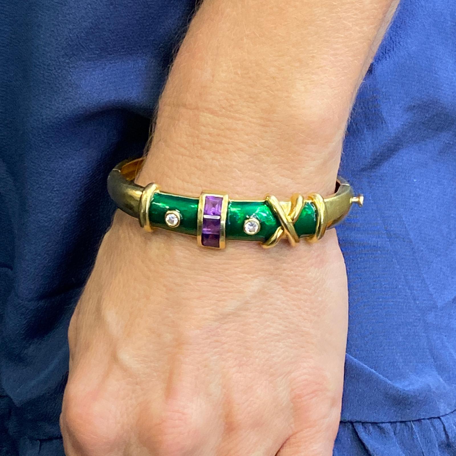 1970's colorful diamond and amethyst bangle fashioned in 18 karat yellow gold and green enamel. The bracelet features 2 round brilliant cut diamonds weighing approximately .32 CTW and graded G-H color and VS2 clarity. The bangle measures .60 inches