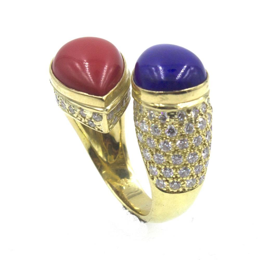 This colorful bypass ring features teardrop shaped coral and lapis gemstones. Fashioned in 18 karat yellow gold, the ring also features 84 round brilliant cut diamonds that weigh approximately 1.60 carat total weight. The ring measures 20mm in